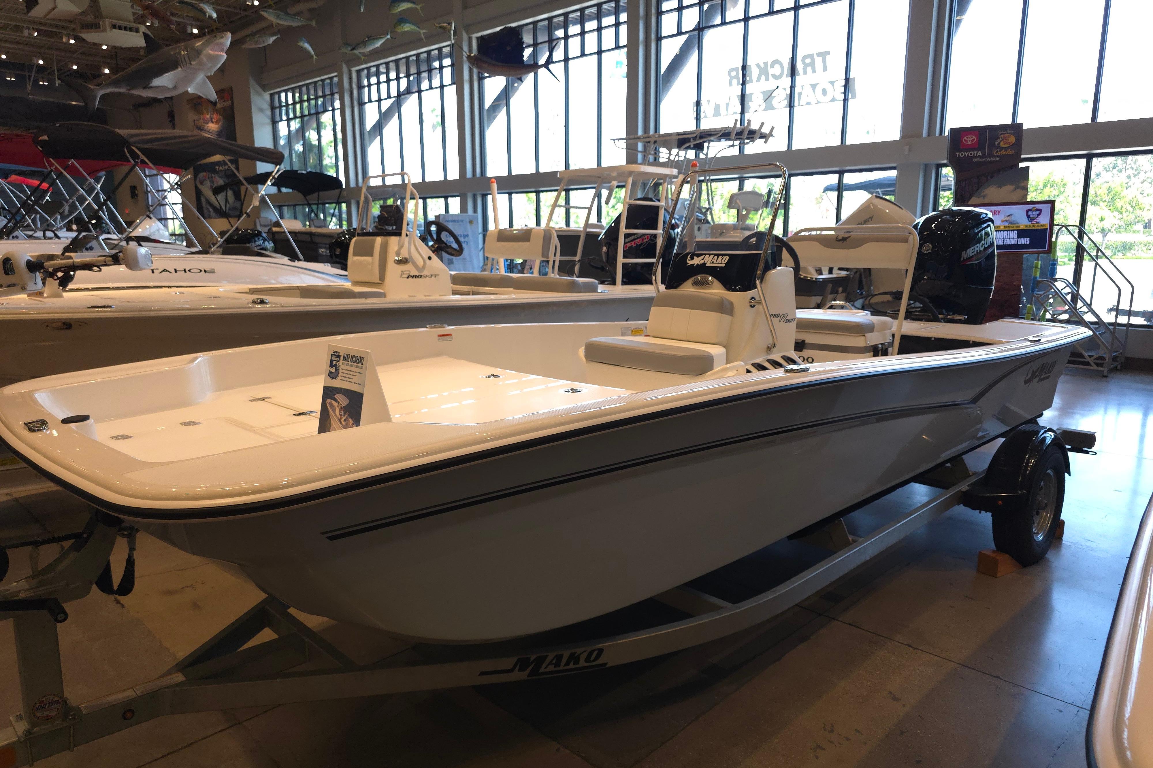 2026 Mako Pro Skiff 17 CC boat displayed in a showroom with other vessels.