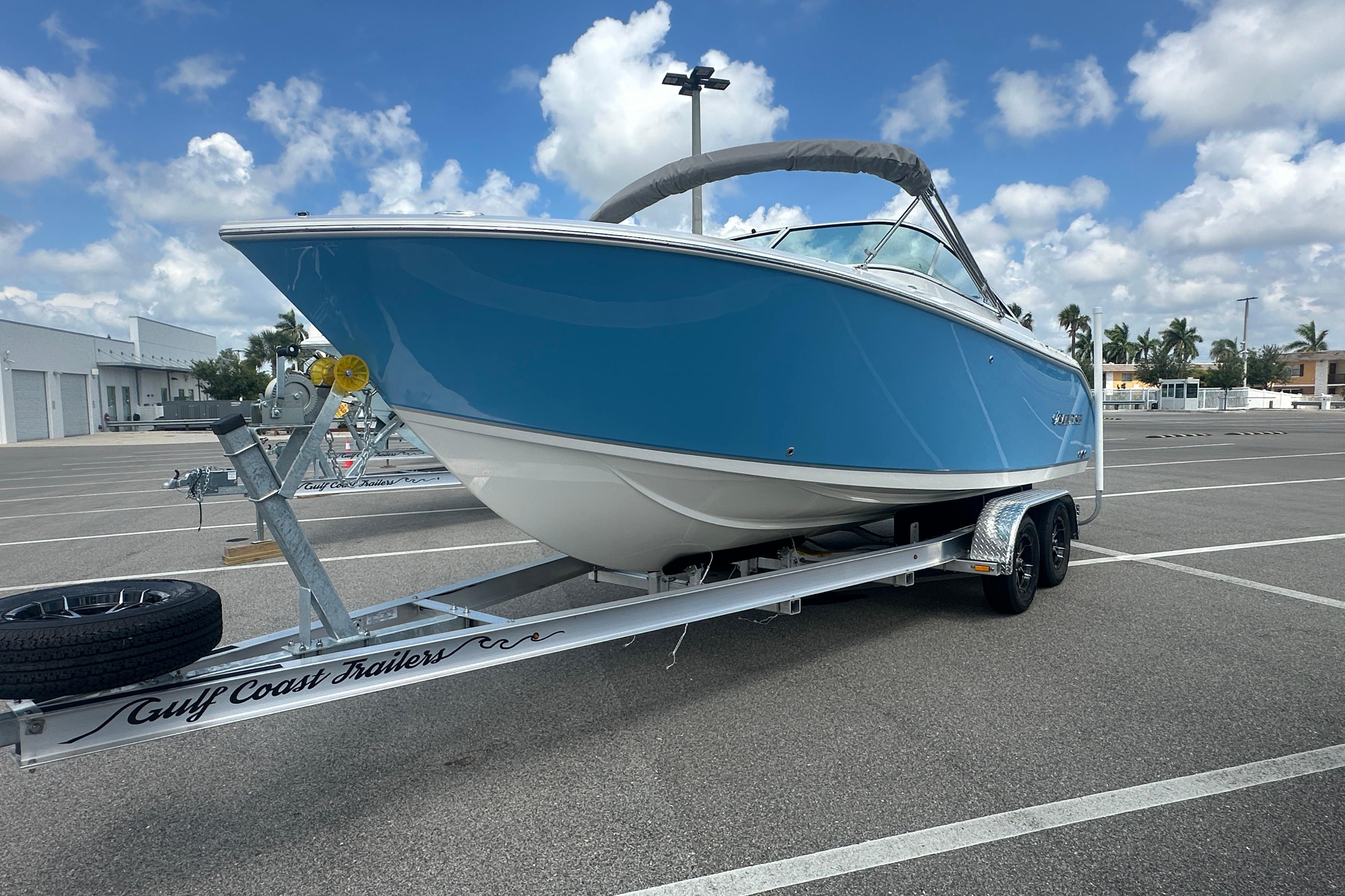 2026 Sailfish 226 DC boat on trailer in parking lot under blue sky.