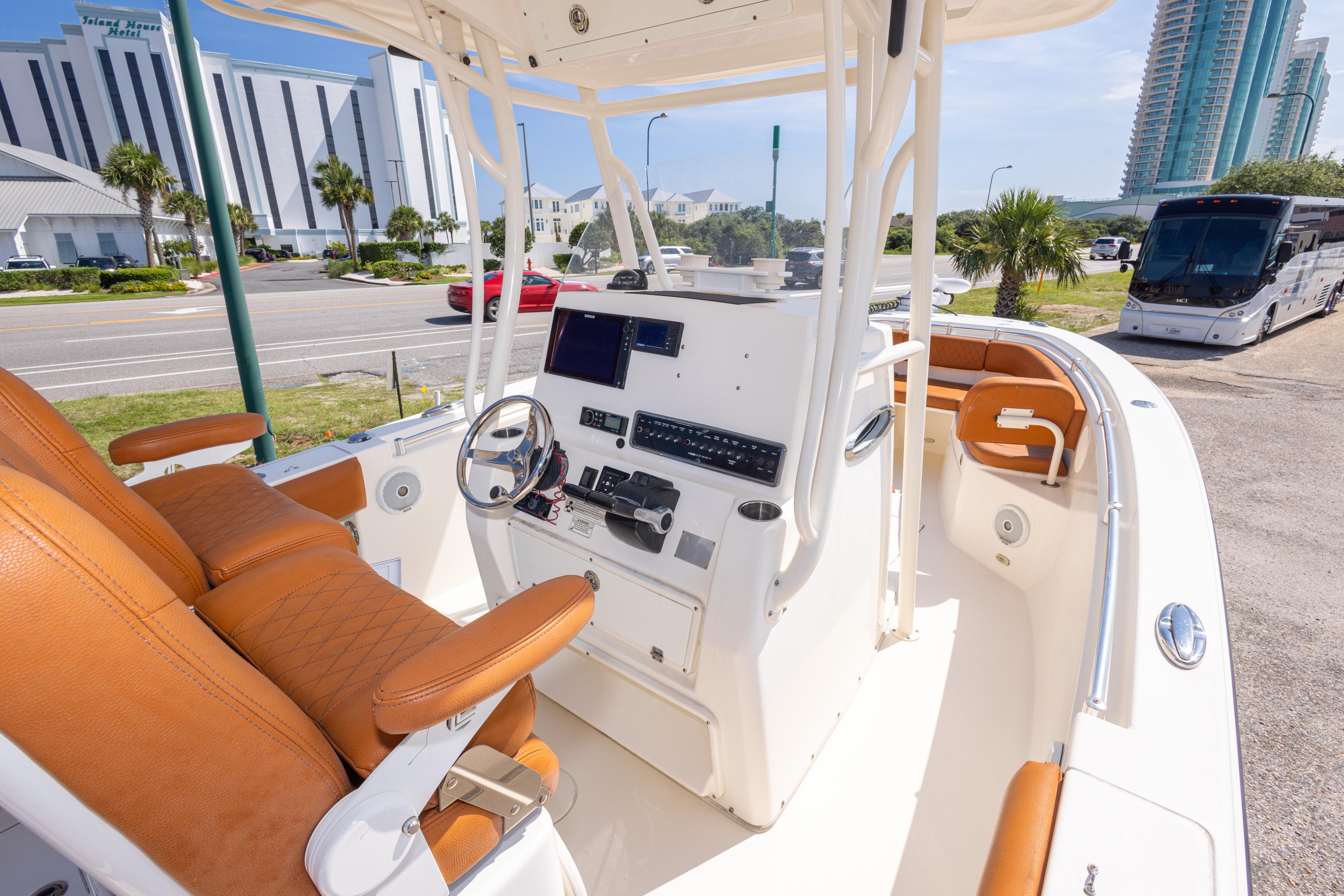 2017 Cobia 261 Center Console boat with tan seating and modern dashboard.