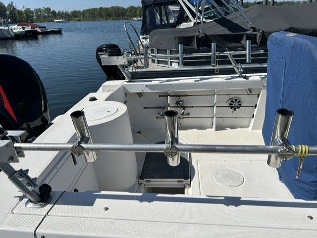 The image shows the cockpit of an Aquasport Osprey 250 boat with fishing rod holders.
