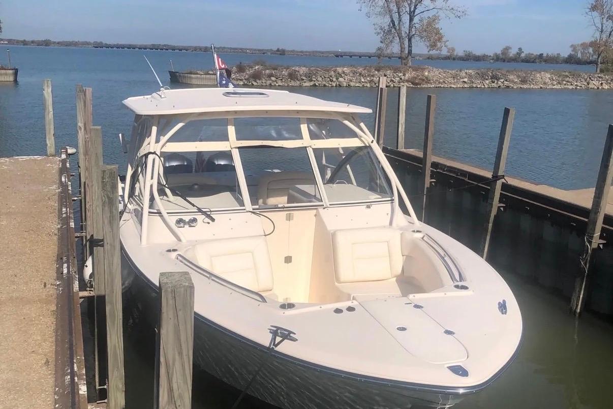 2019 Grady-White Freedom 307 boat docked by a serene lake.