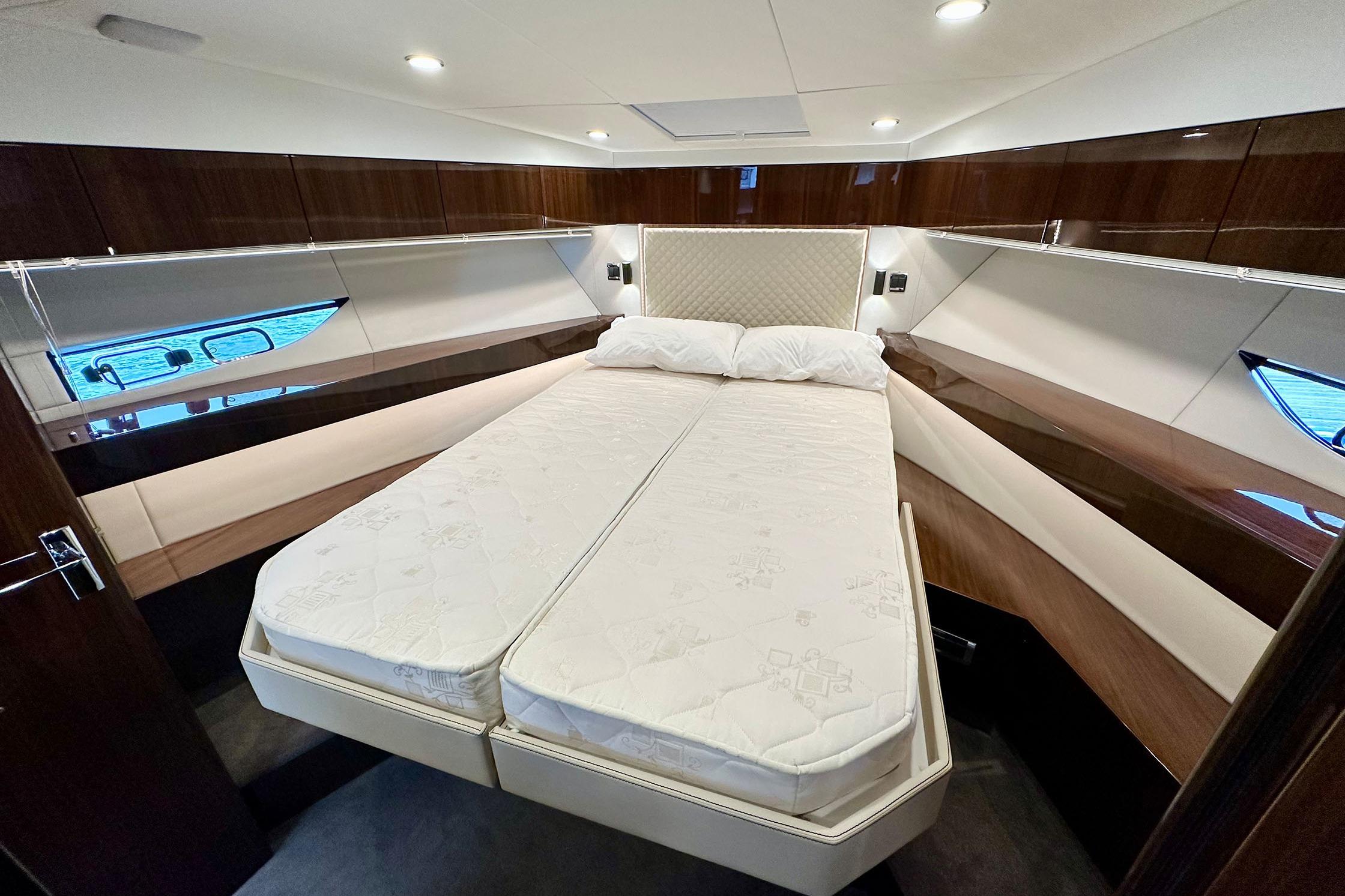 Luxurious bedroom interior of 2022 Fairline Targa 50 GT yacht with elegant wood finishes.