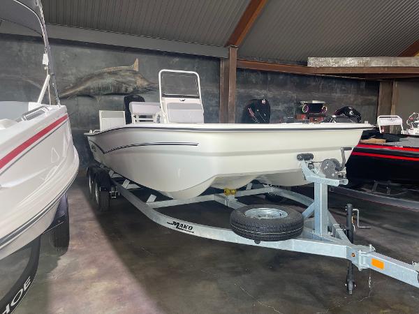 2024 Mako Pro Skiff 19 CC boat on a trailer in a showroom.