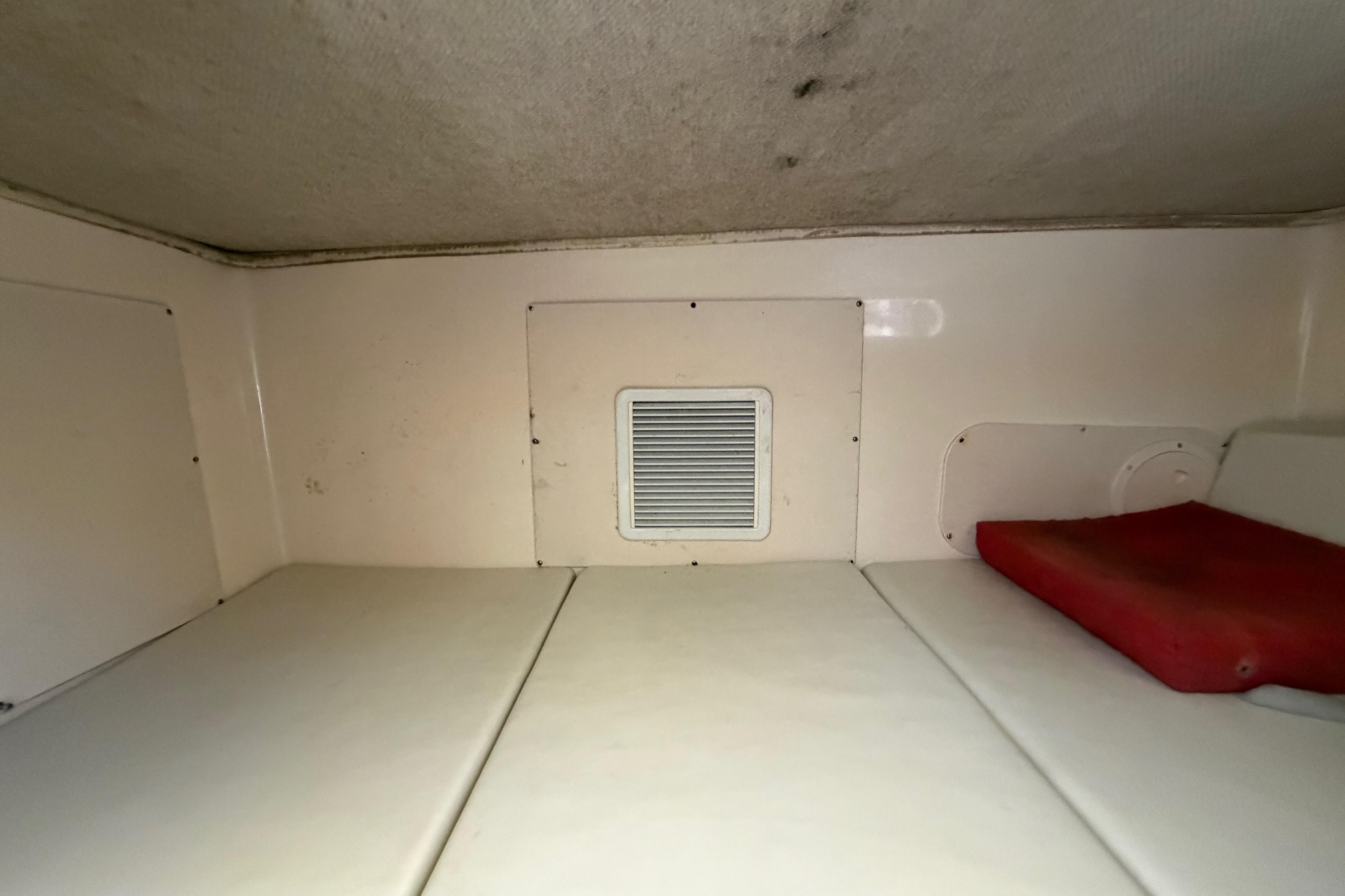2006 Grady-White Sailfish 282 cabin interior with white cushions and ventilation panel.