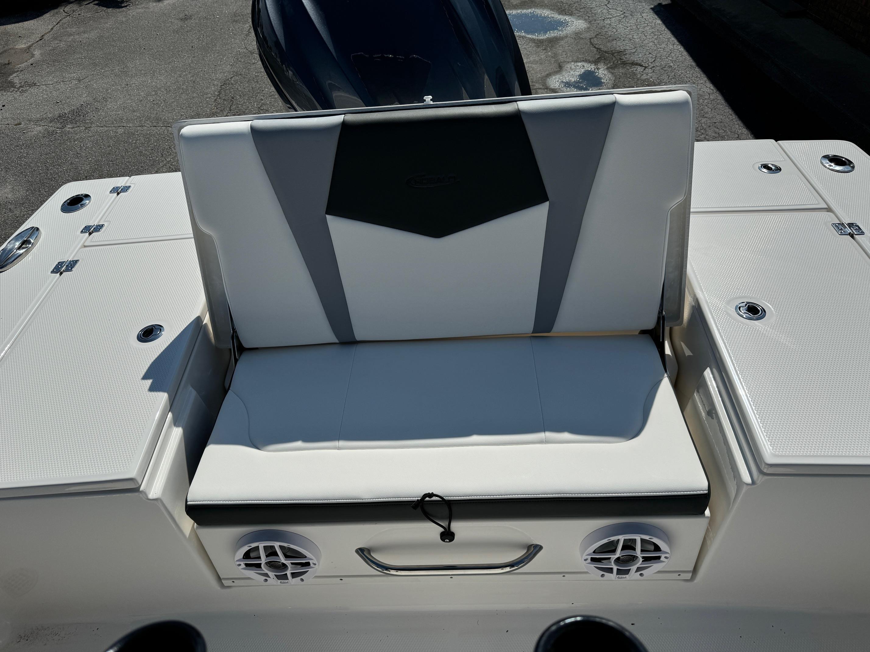 2025 Robalo R246 CAYMAN boat seating area with integrated speakers and storage compartments.