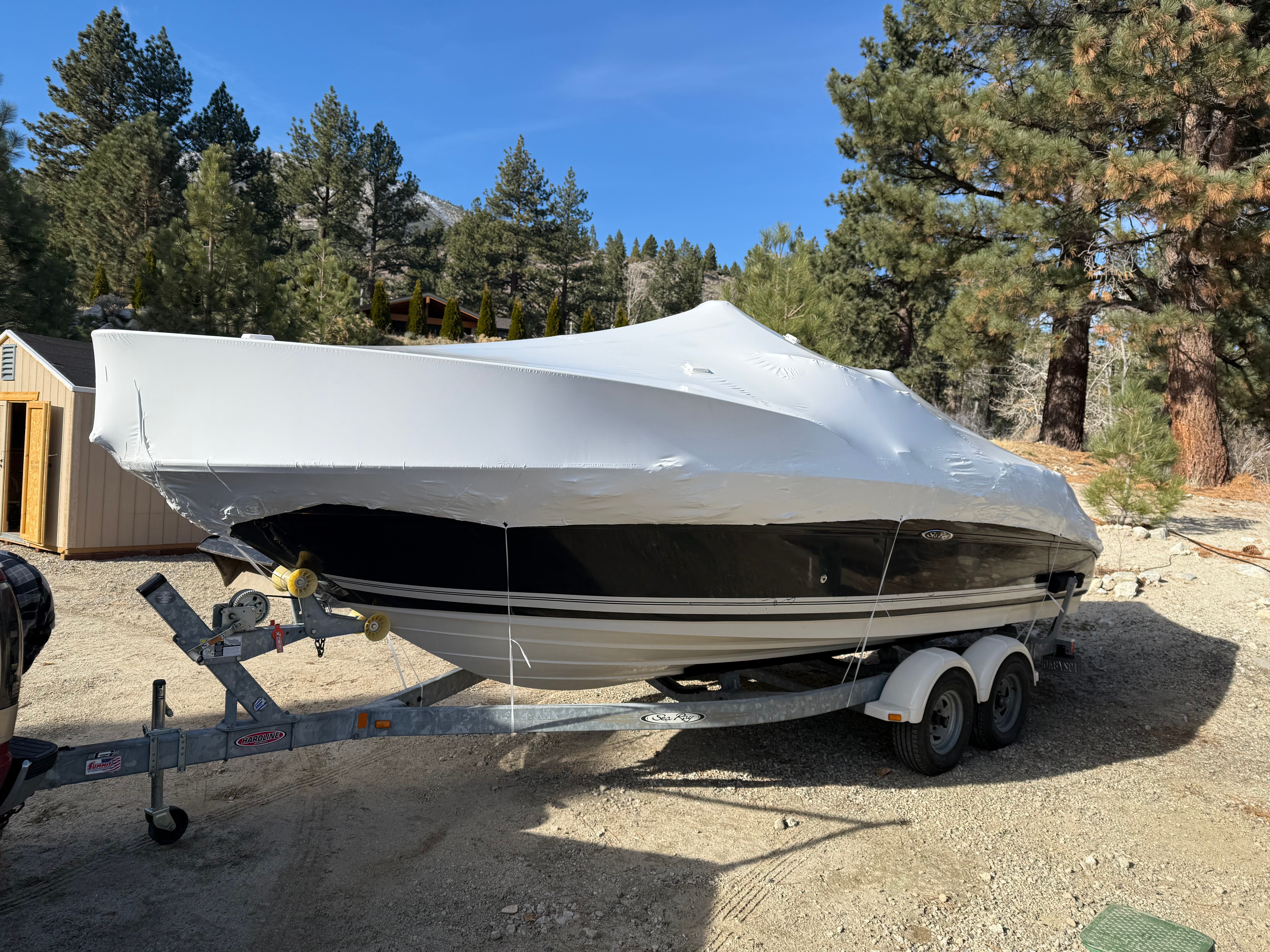 2007 Sea Ray 215 Weekender boat on trailer, covered, parked outdoors.