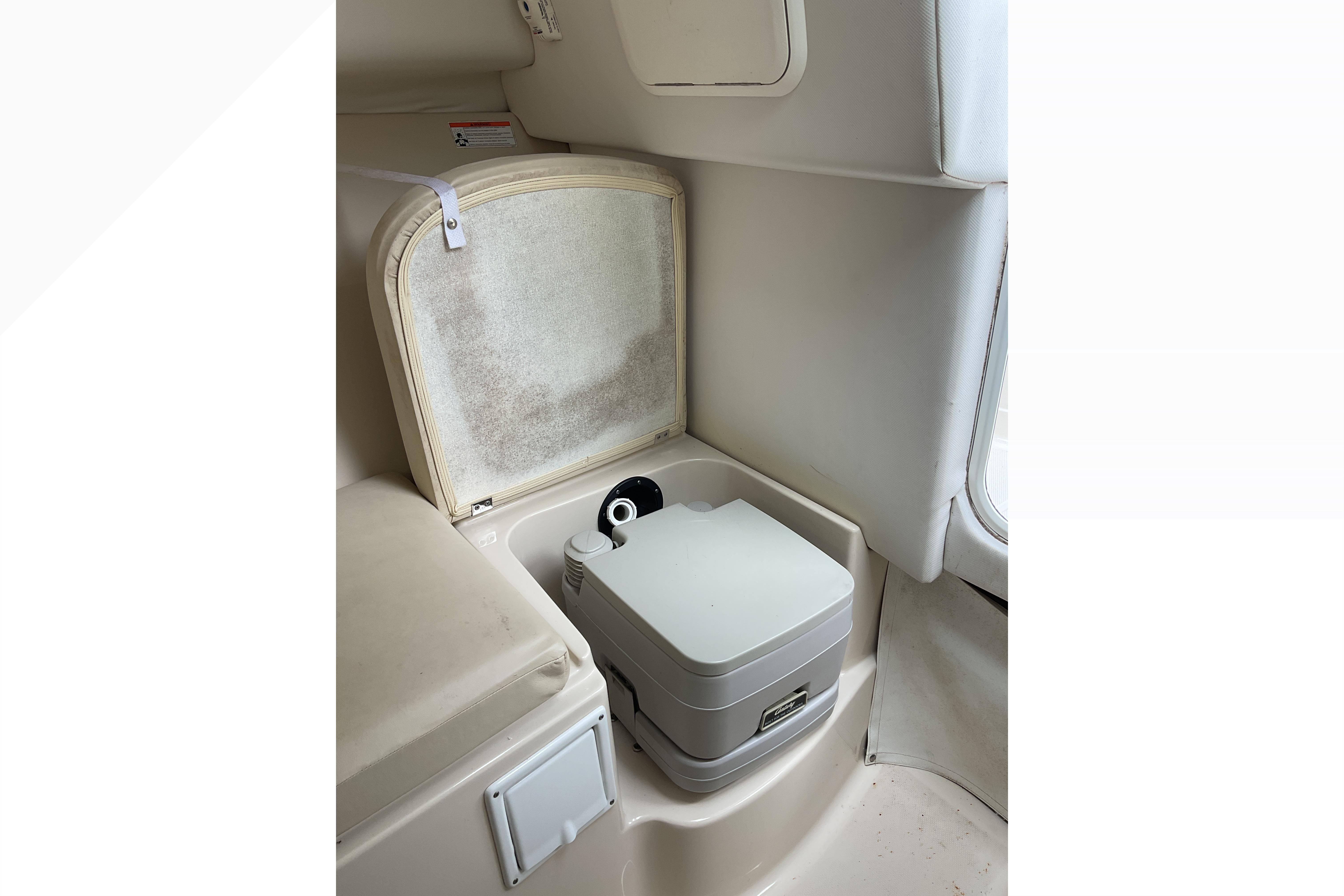 Interior of 2012 Wellcraft 232 Coastal boat featuring a compact marine toilet.