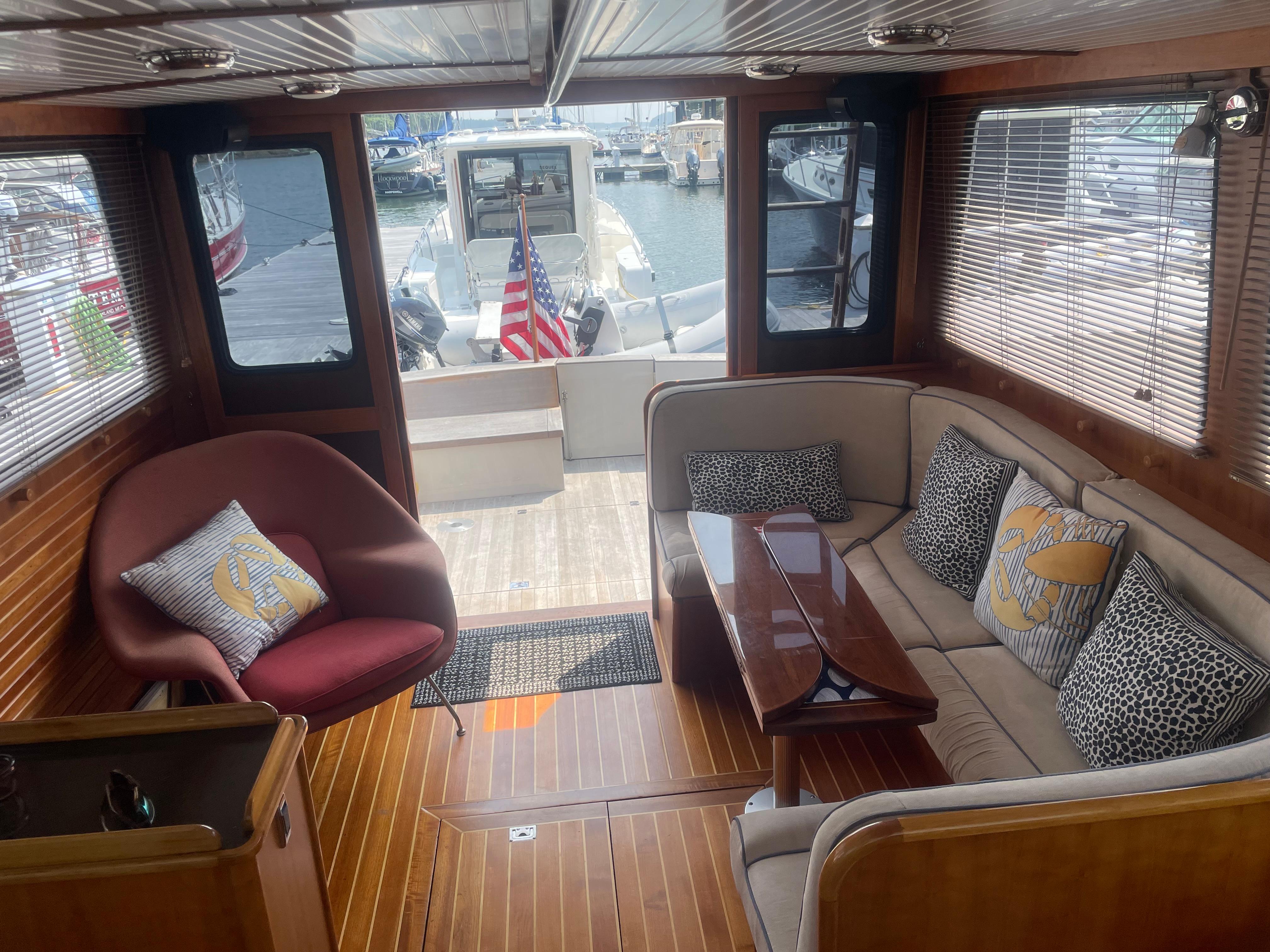 Luxurious 1997 Lyman-Morse Custom Flybridge interior with elegant seating and wooden flooring.