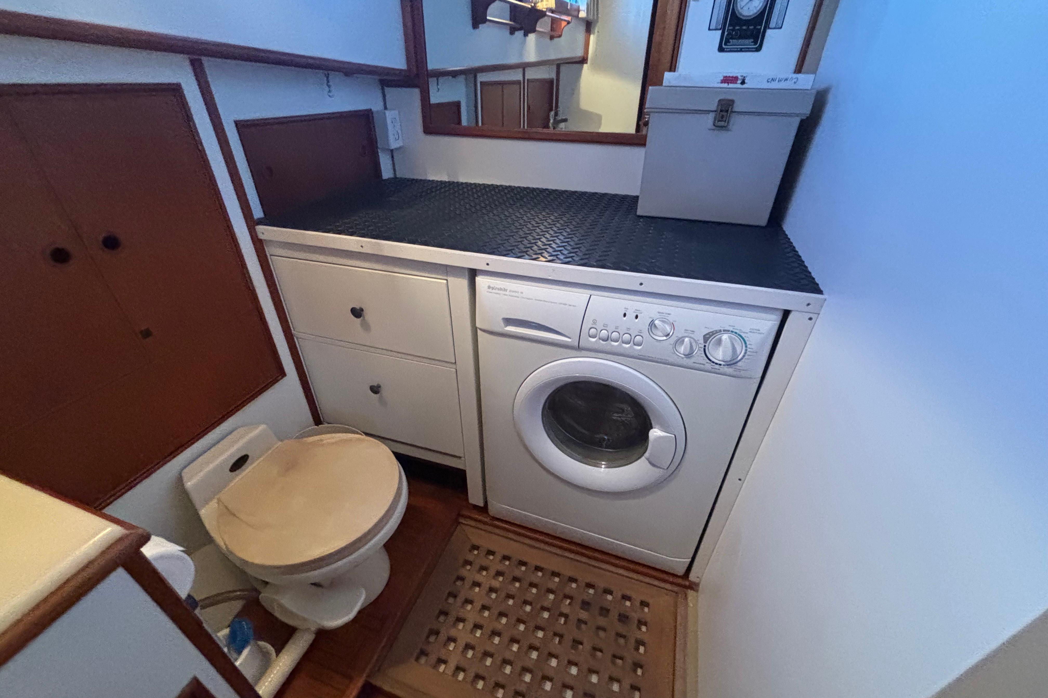 Laundry area with washer and toilet on 1989 Grand Banks 46 Classic yacht.