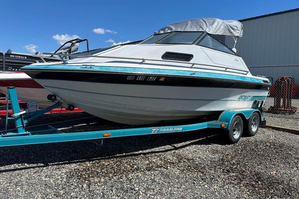 1992 Reinell 192 RM boat on trailer, parked outdoors under clear blue sky.