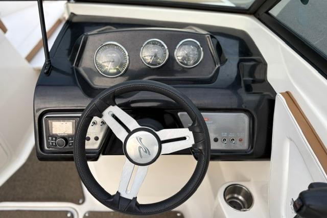 Steering wheel and dashboard of a 2017 Searay SPX210 boat, featuring gauges and controls.