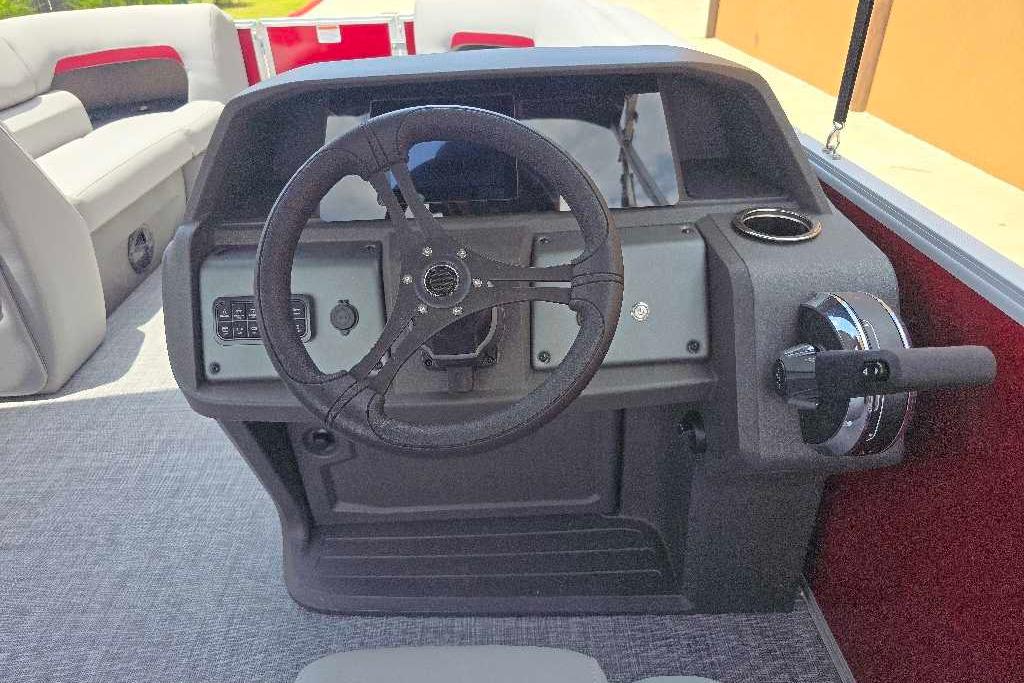 2026 Sun Tracker Party Barge 20 DLX steering console with seating in background.