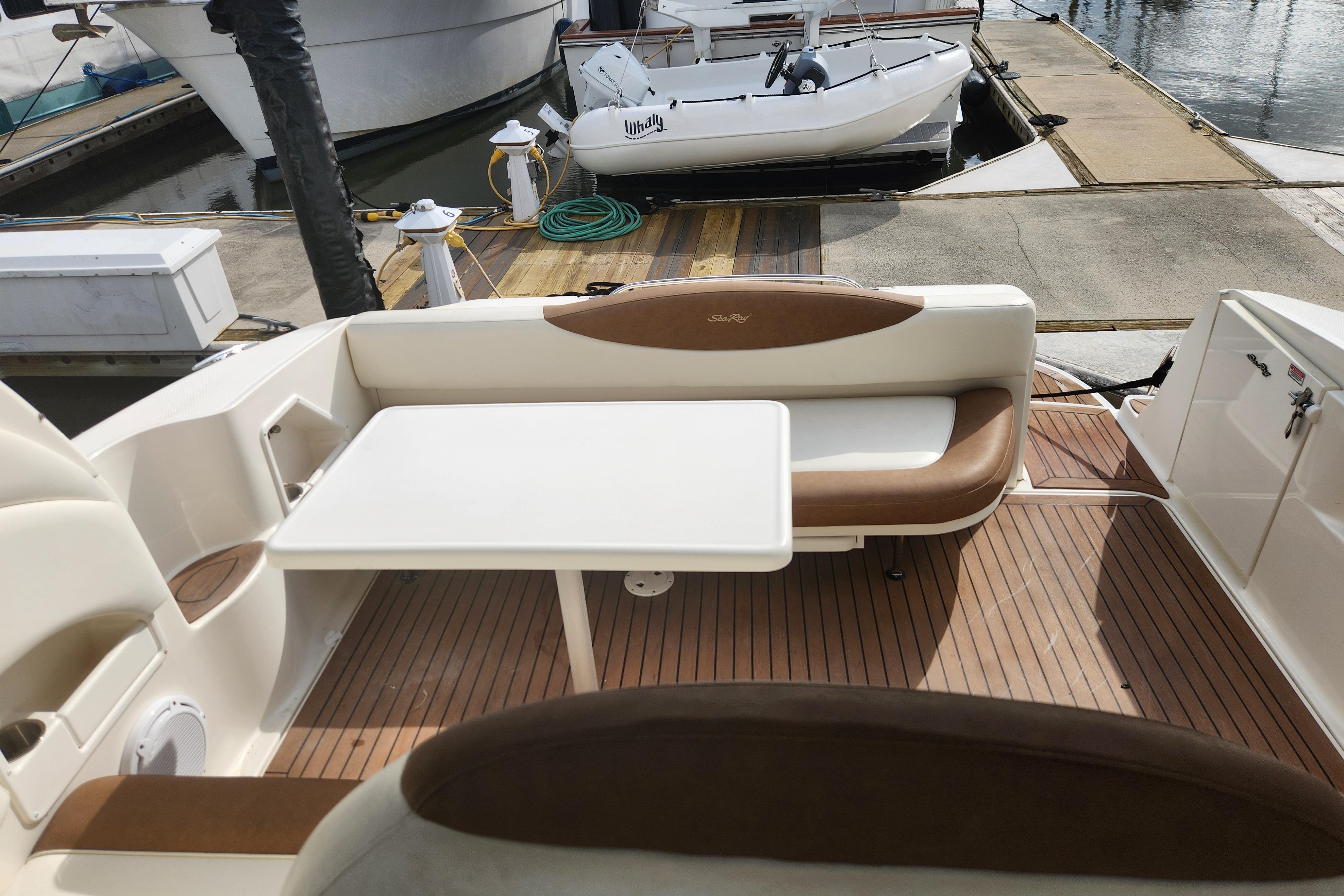 2003 Sea Ray 360 Sundancer boat interior with seating and table at dock.