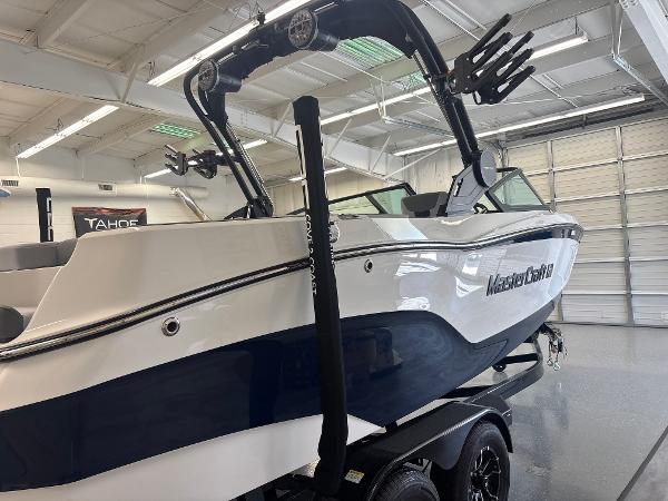 2025 MasterCraft XT22 boat in showroom, featuring sleek design and modern features.