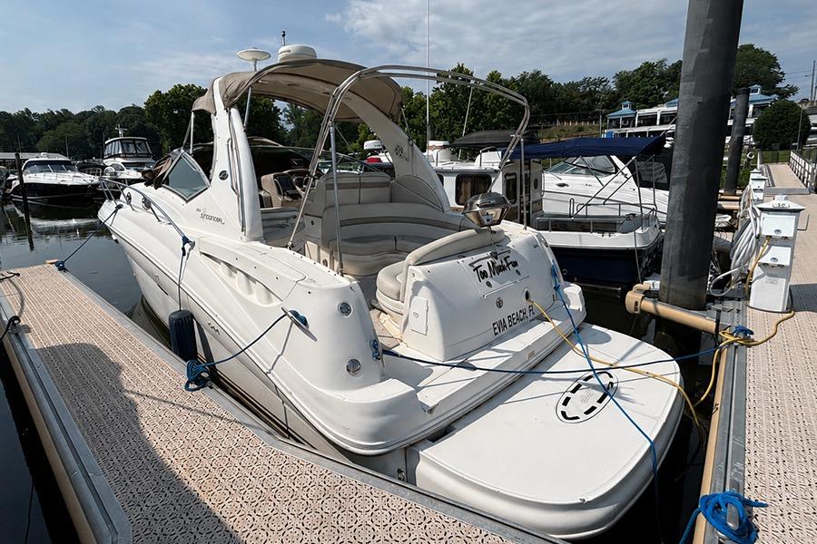 2002 Sea Ray Sundancer 320 docked at marina, showcasing sleek design and spacious deck.