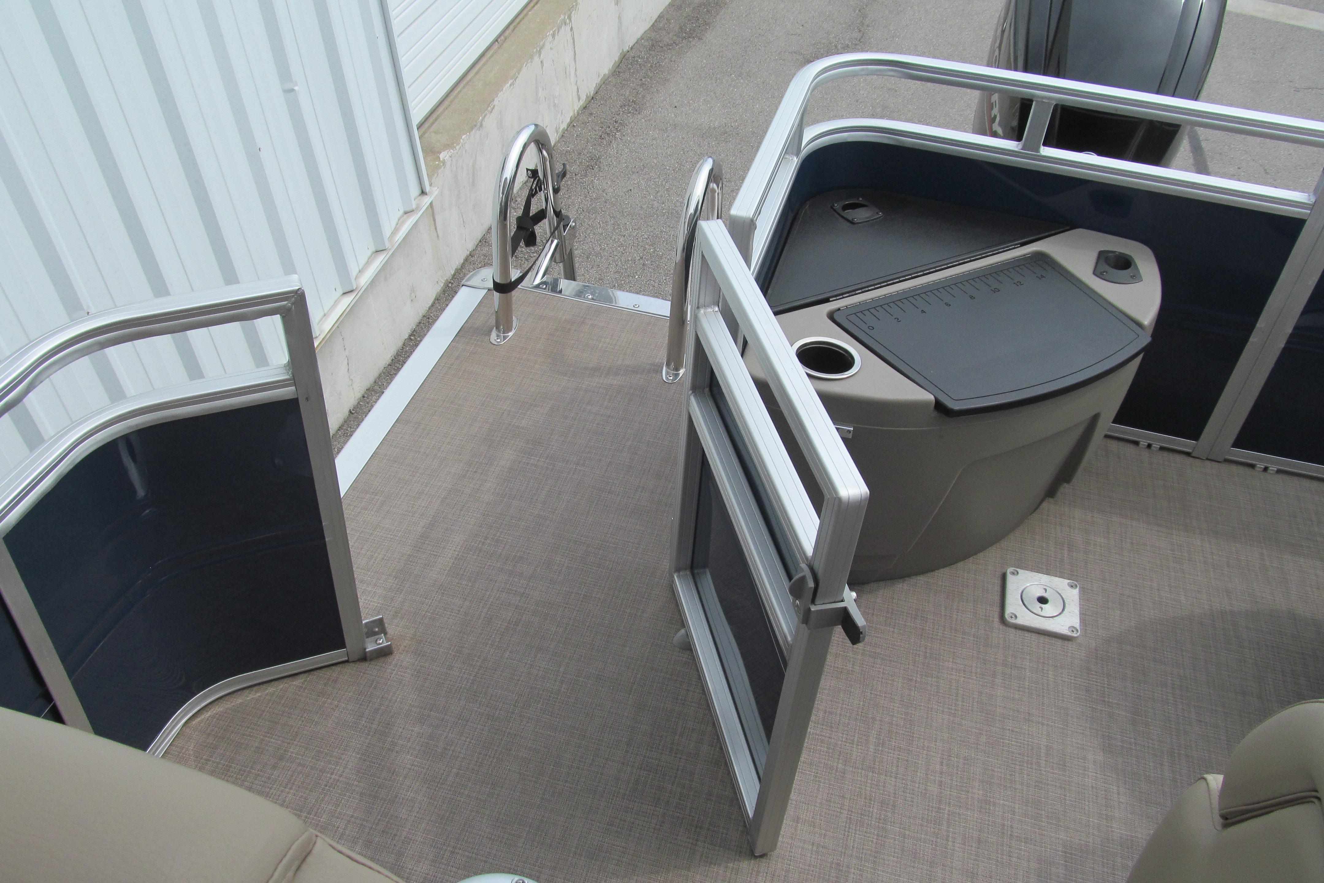 2024 Sun Tracker Fishin' Barge 20 DLX deck with open gate and storage area.