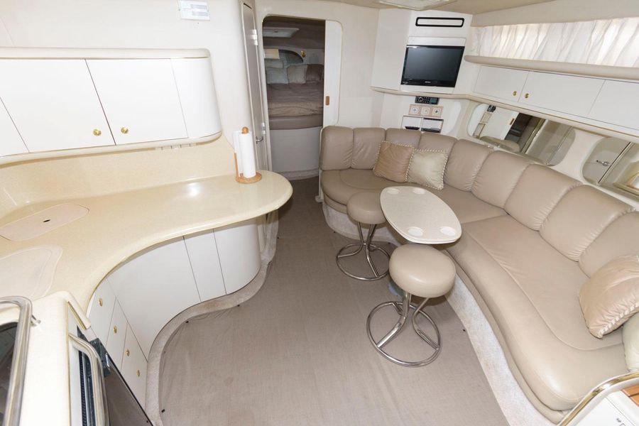 Interior of a 1998 Sea Ray Sundancer 370 yacht with sofa and kitchenette.