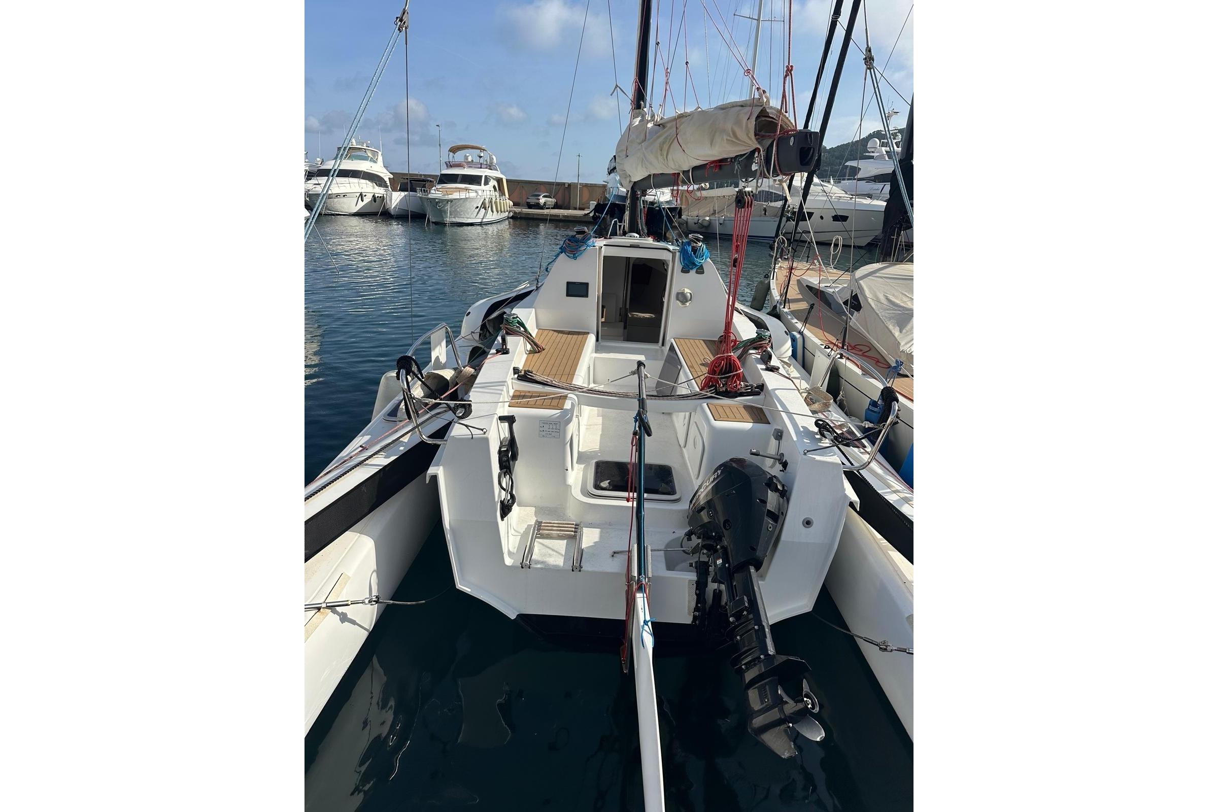 2021 TRICAT 30 sailboat docked in marina, featuring outboard motor and spacious deck.