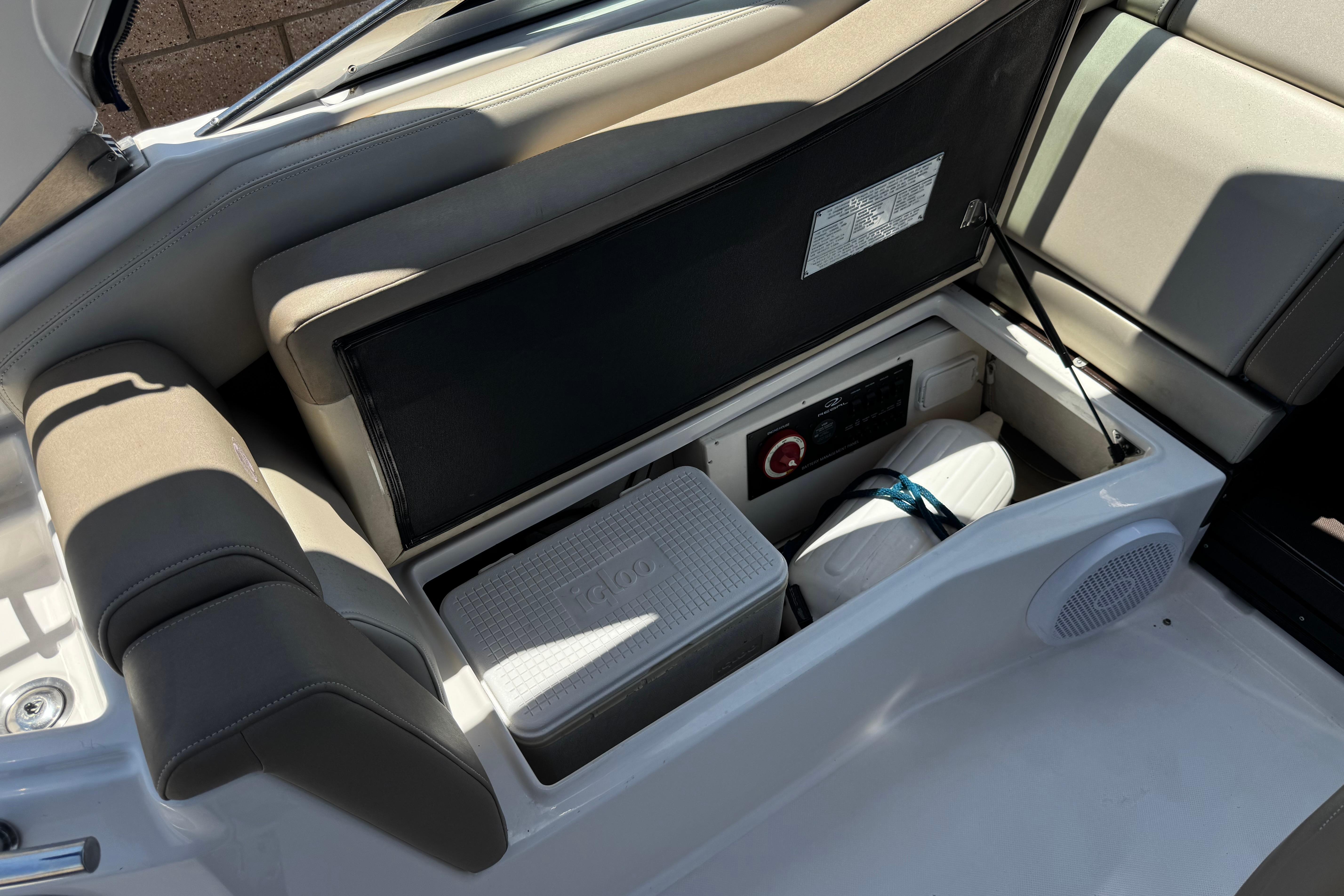 Interior storage compartment of a 2013 Regal 28 Express boat with cooler and equipment.