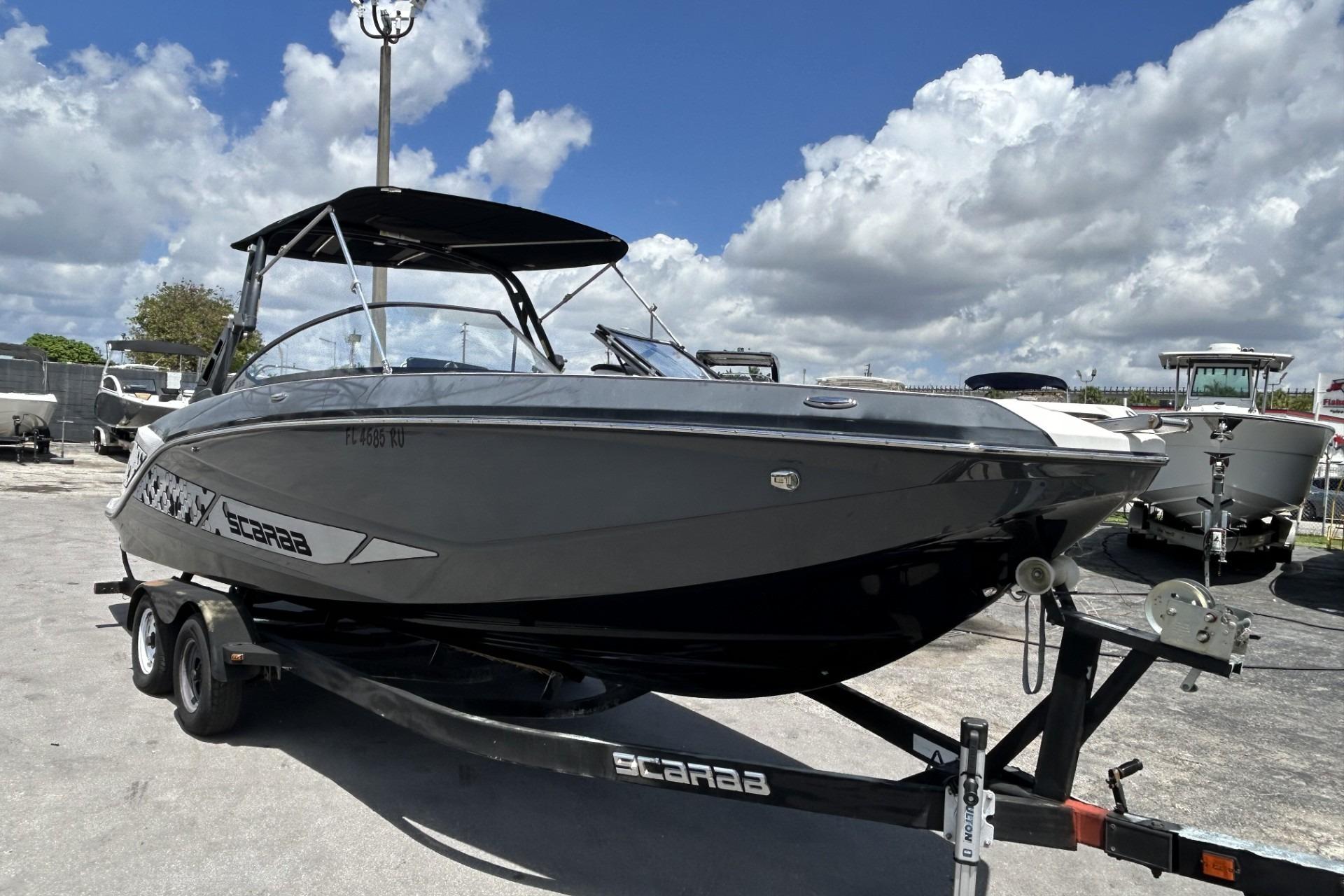 2019 Scarab 255 ID boat on trailer under cloudy sky.