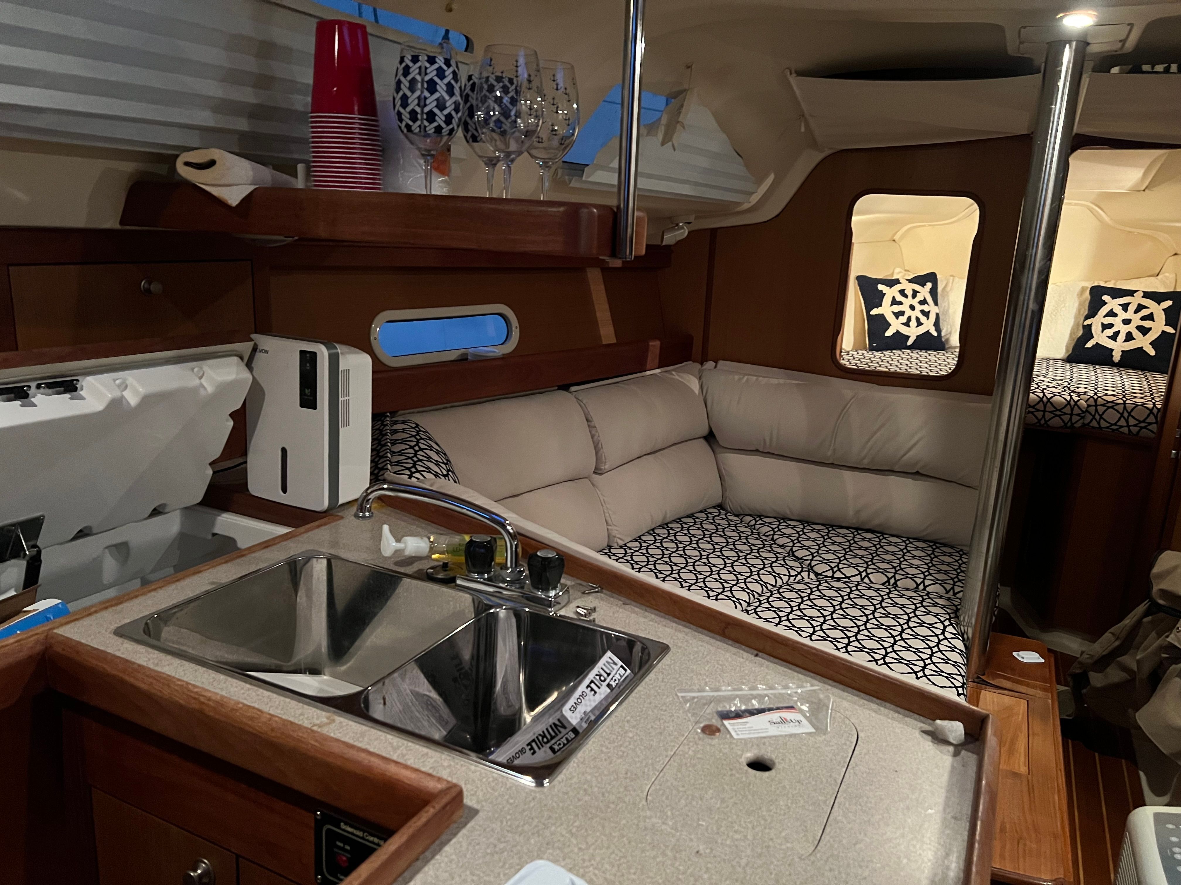 Interior of a sailboat with a kitchen and cozy seating area.