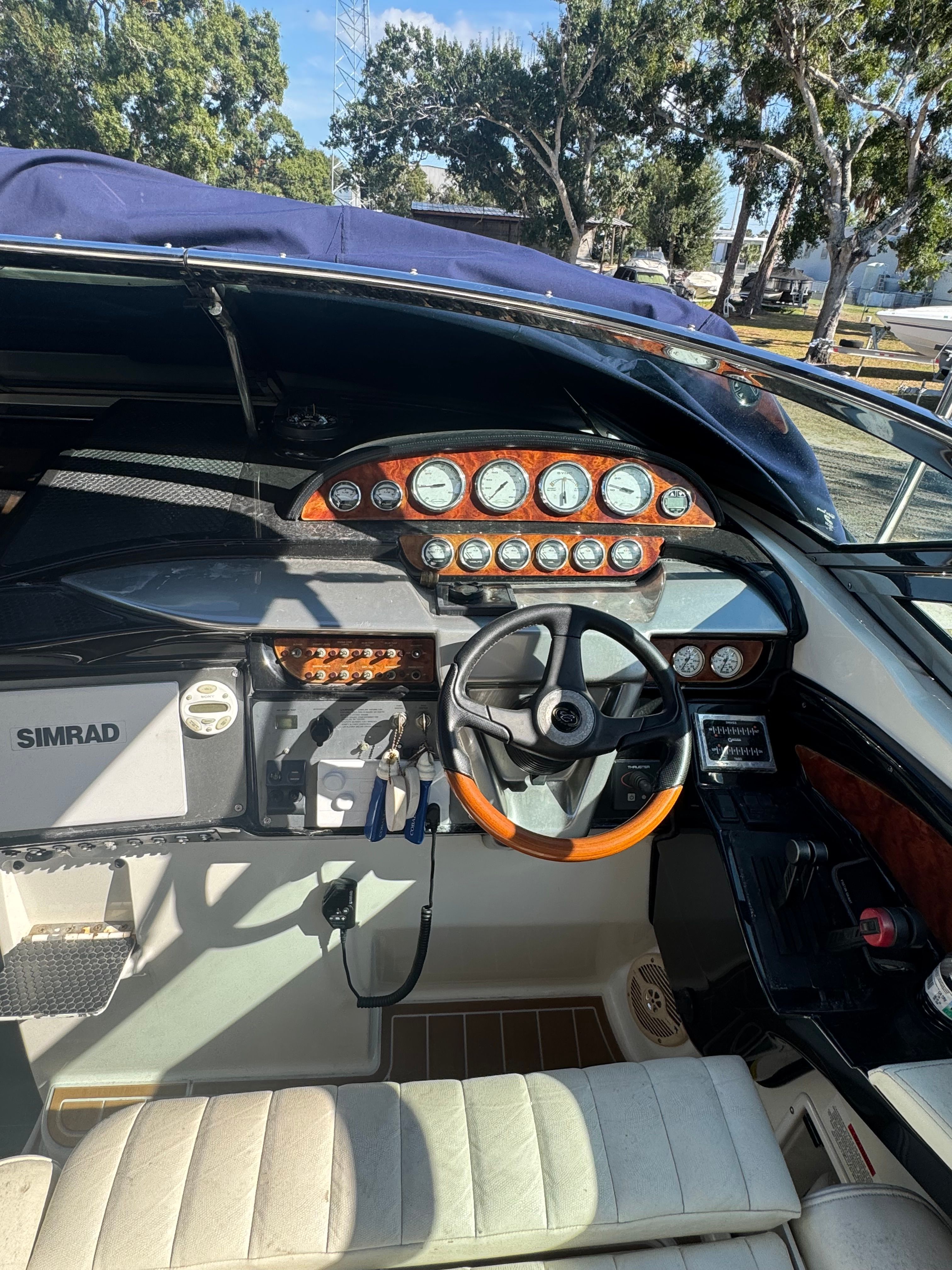 The cockpit of a 2003 Cobalt 360 with a sleek dashboard and wooden steering wheel.