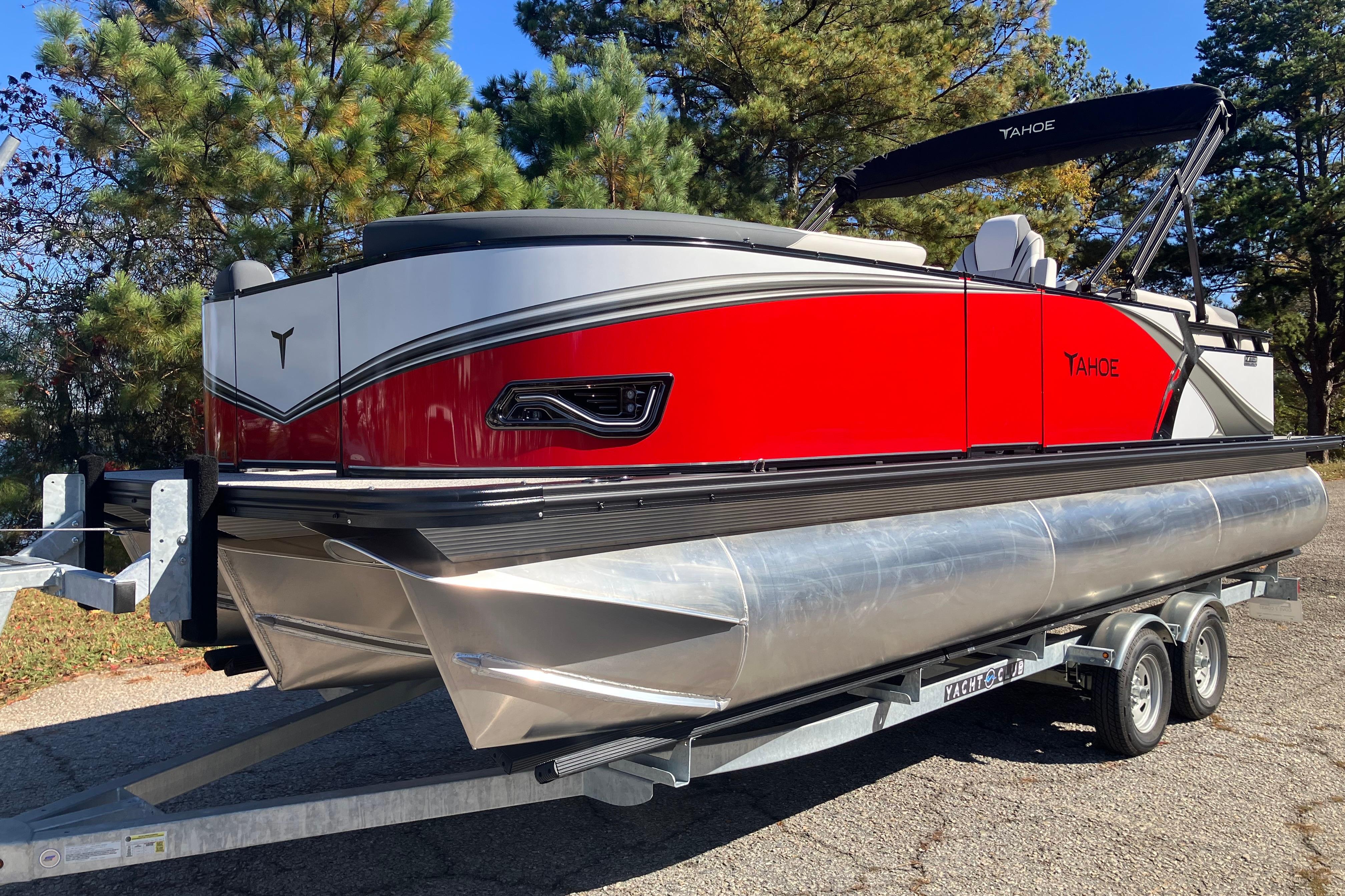 2026 Tahoe Pontoon LTZ Quad Lounger on trailer, vibrant red design, parked outdoors.