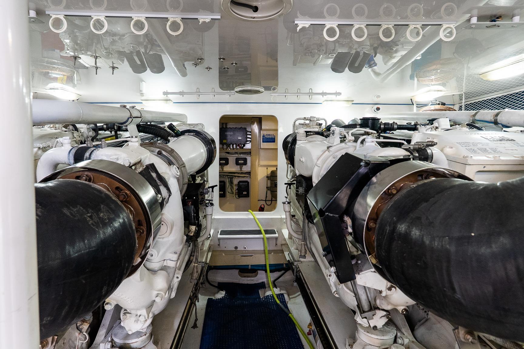 Engine room of 2002 Viking 61 Enclosed Bridge yacht, showcasing dual engines and equipment.