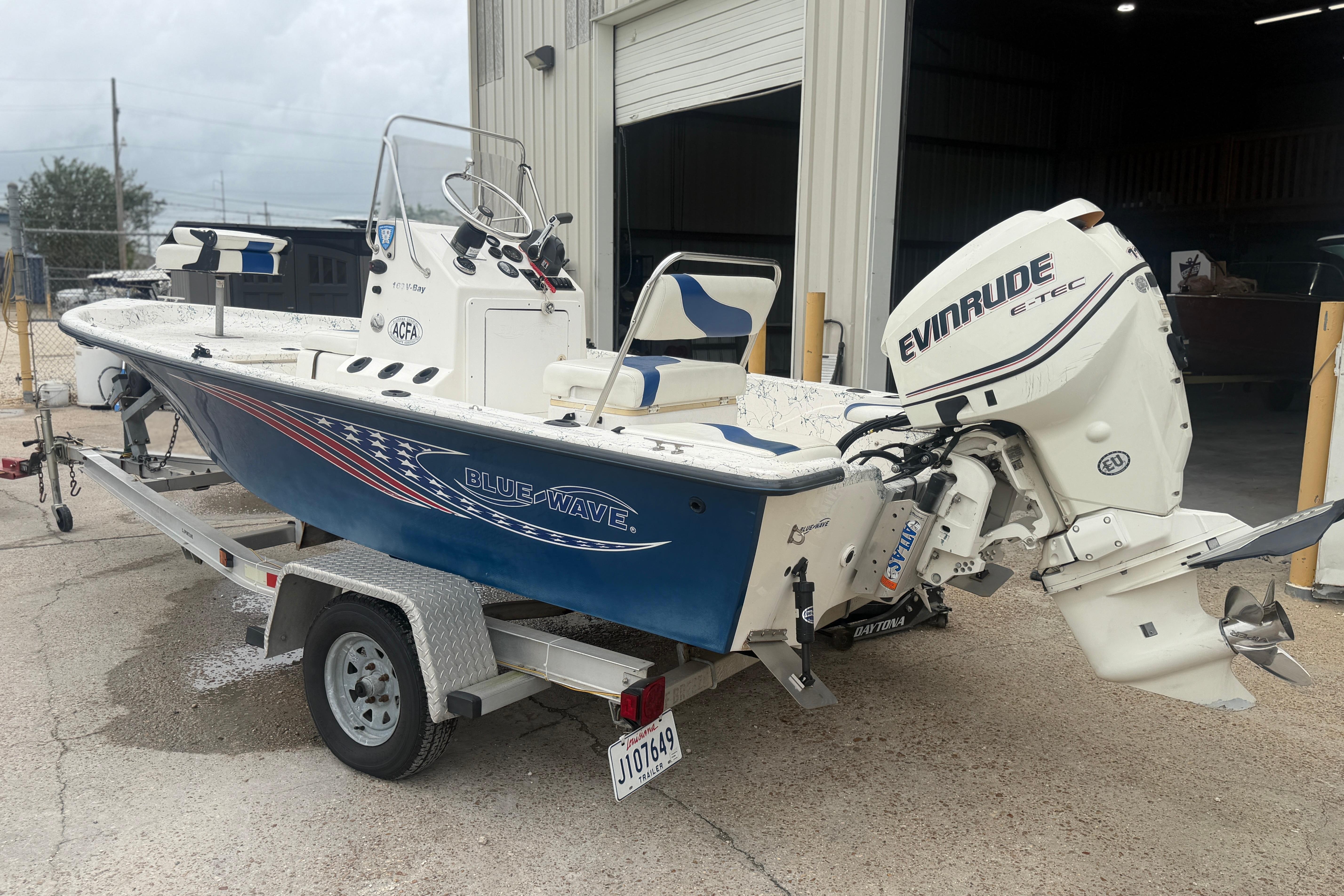 2004 Blue Wave 160 V-Bay boat with Evinrude E-TEC engine on trailer.