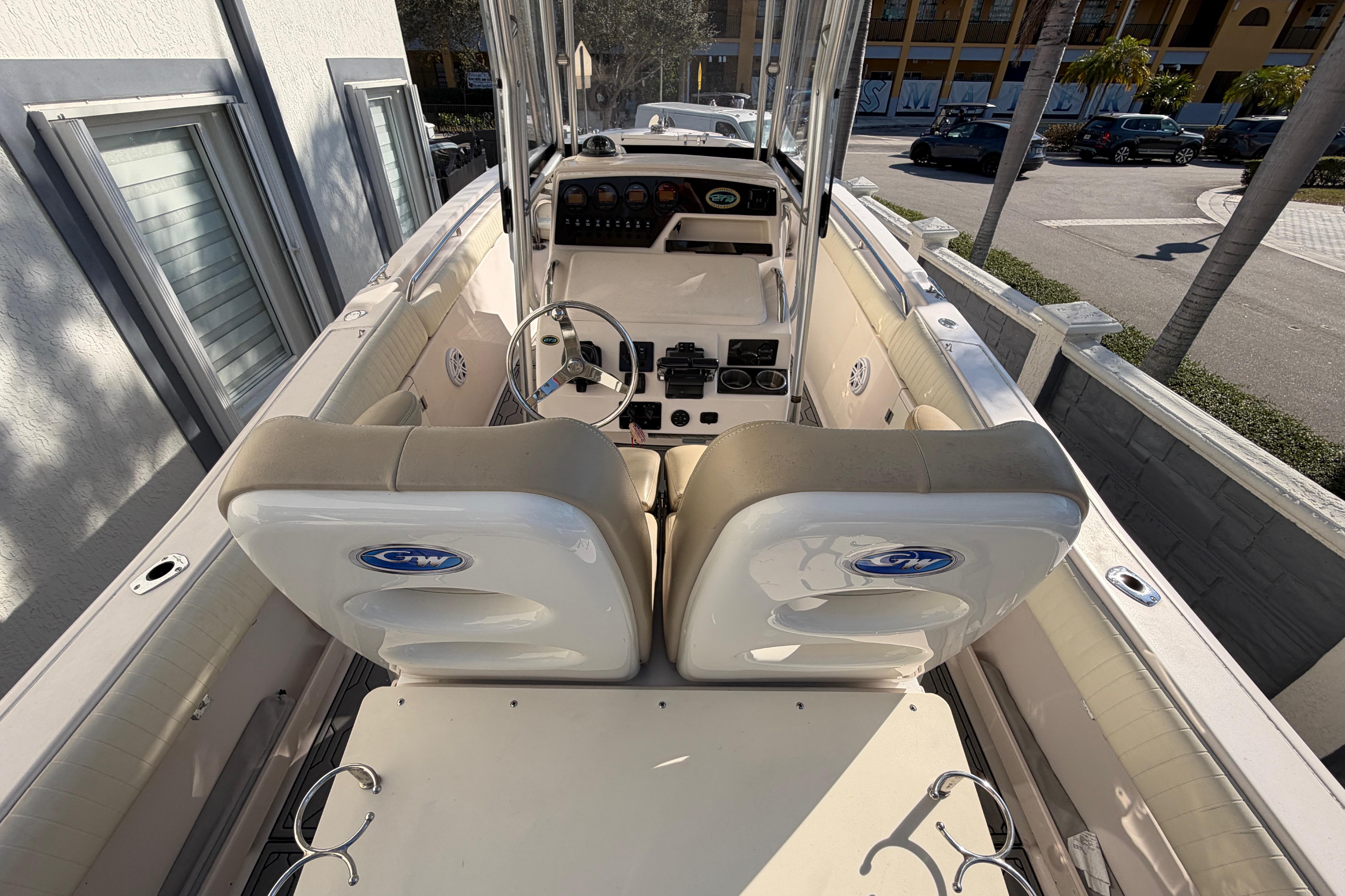 2004 Grady White 273 boat interior with steering wheel and seating, docked near a building.