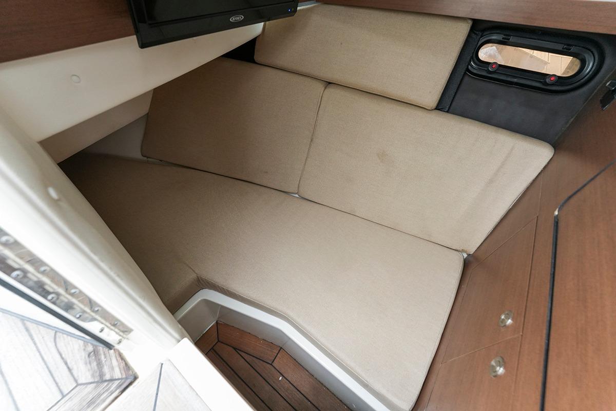 2018 Sea Ray SLX 350 cabin interior with beige cushions and wooden accents.