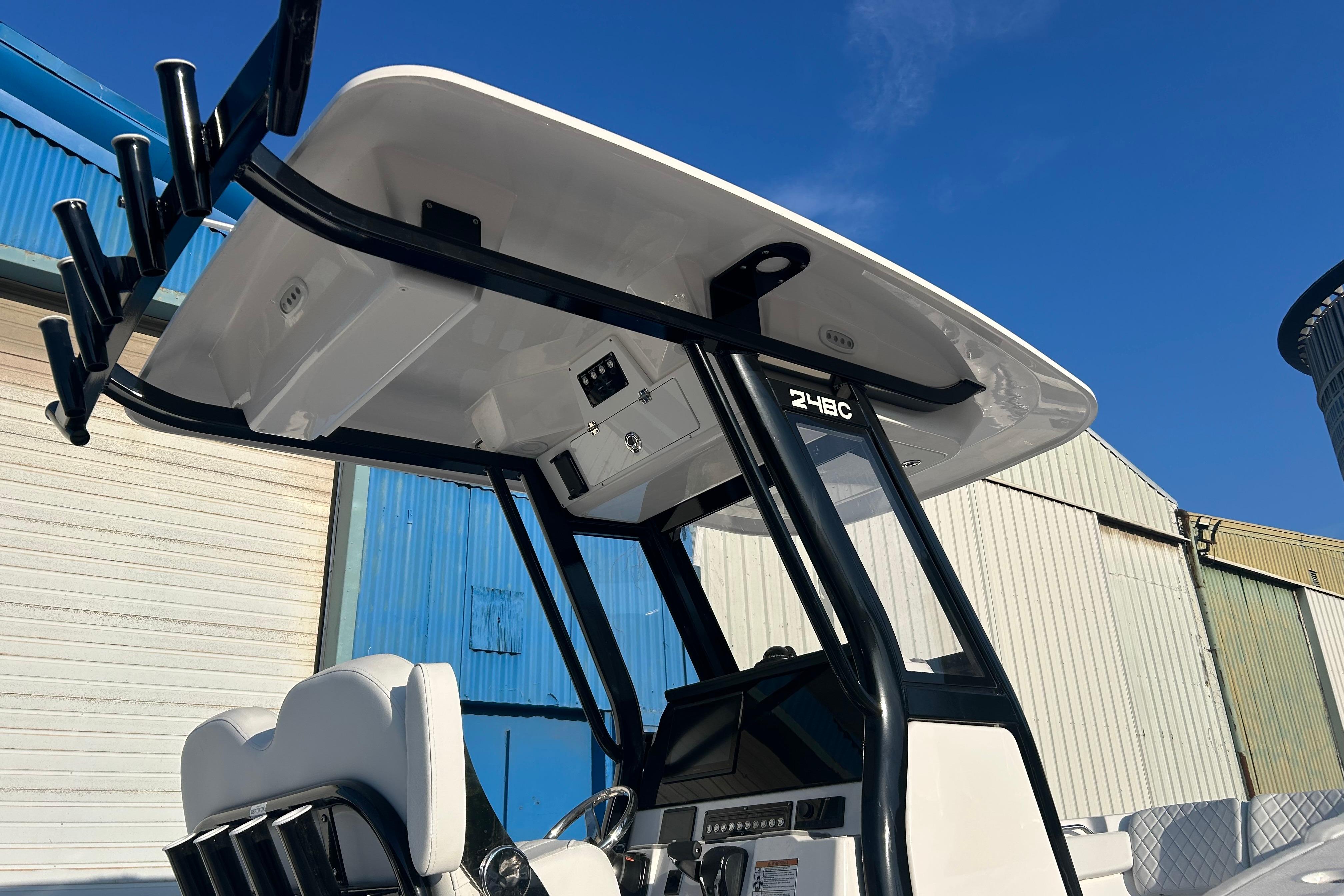 2026 Sea Fox 248 Commander boat console with T-top against blue sky.