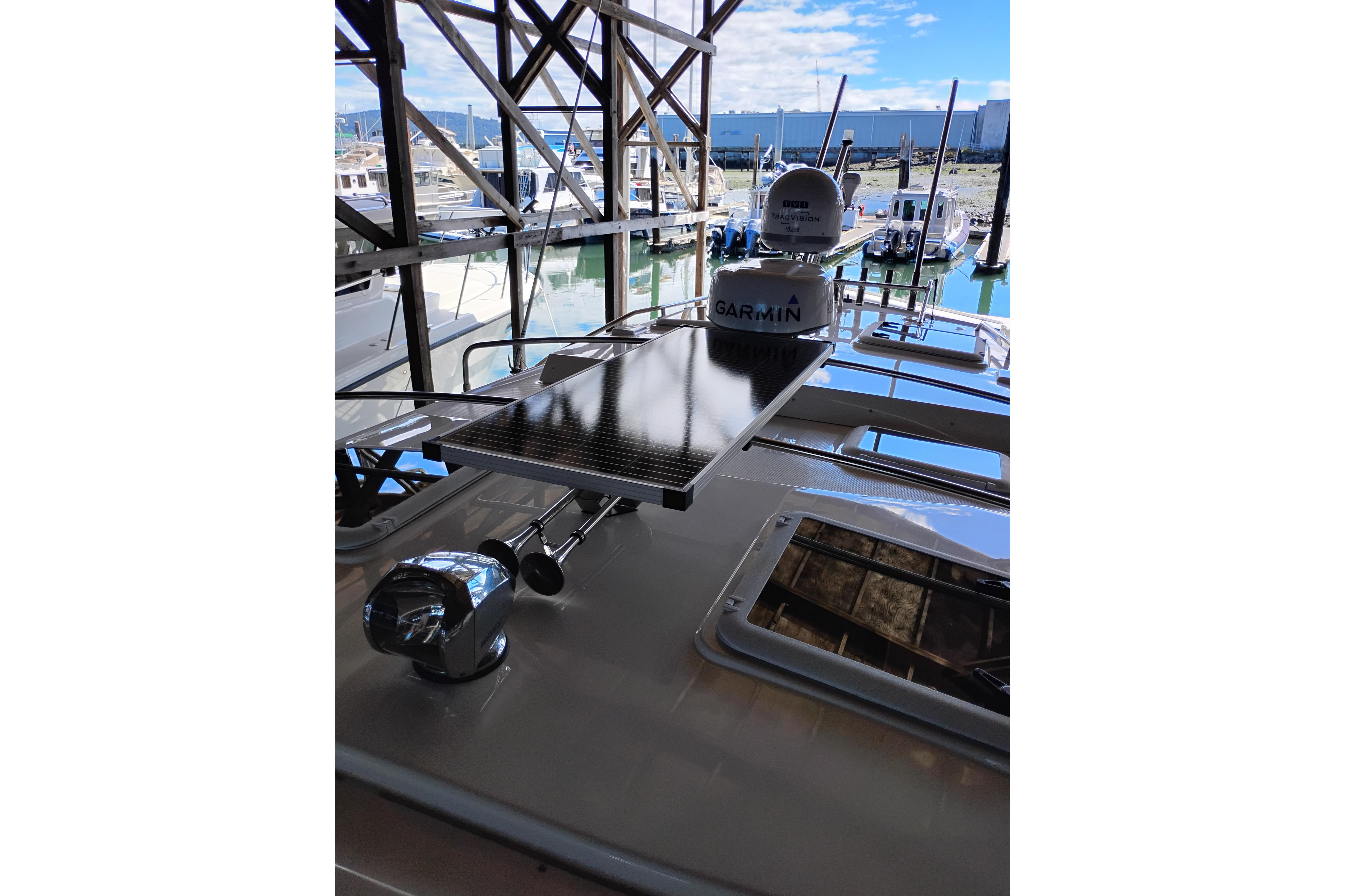 2022 Cutwater C-32 Coupe boat with Garmin equipment, docked in a marina.