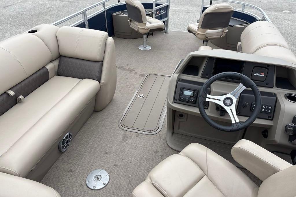 2025 Sun Tracker Fishin' Barge 22 XP3 interior with beige seating and steering console.