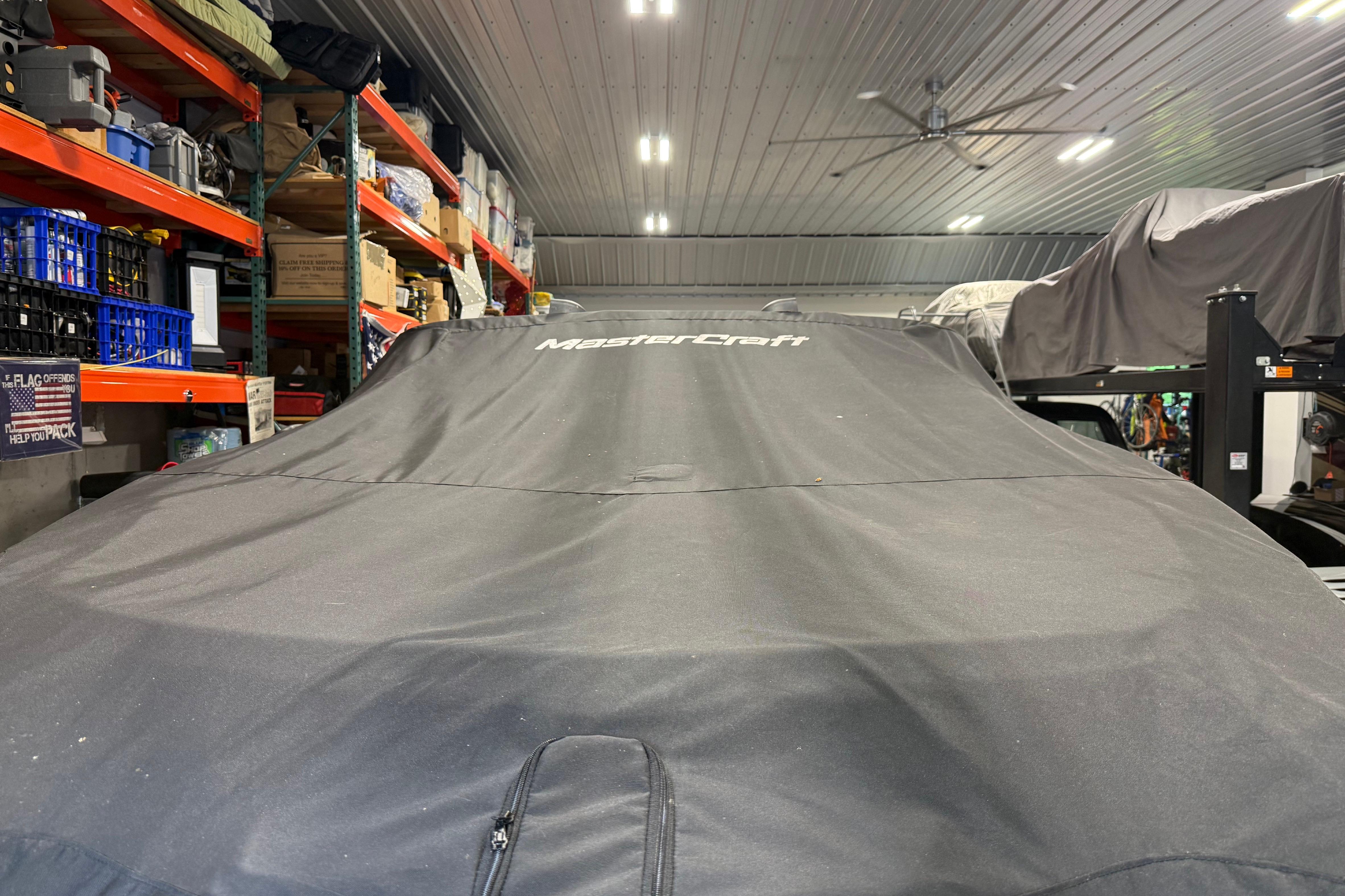 2022 MasterCraft NXT24 boat covered in storage, surrounded by shelves and equipment.