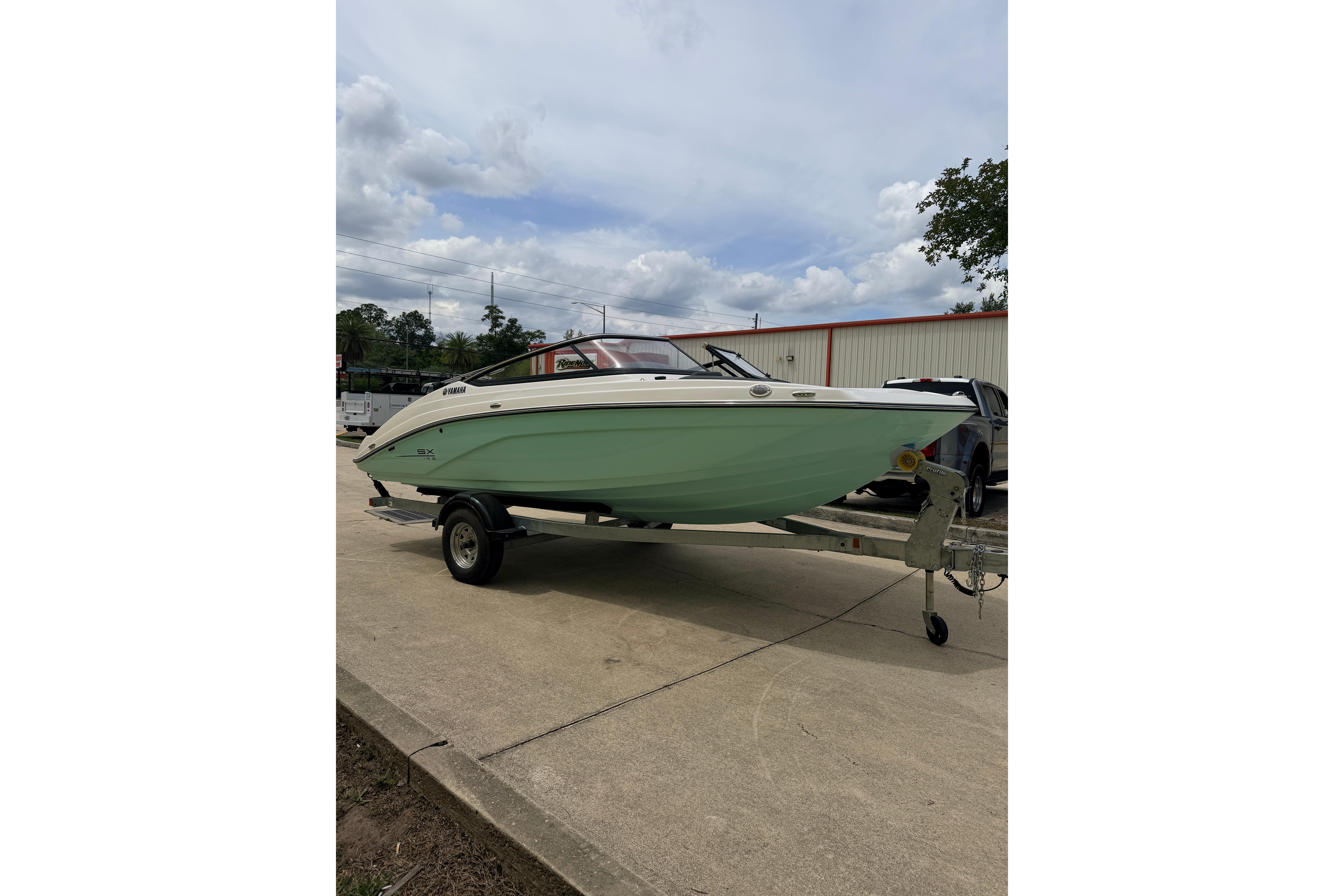 2026 Yamaha Boats SX195 on trailer, parked outdoors under cloudy sky.