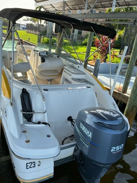 A 2008 Hurricane Sun Deck 24 with a Yamaha outboard motor. It features a black bimini top and is docked.