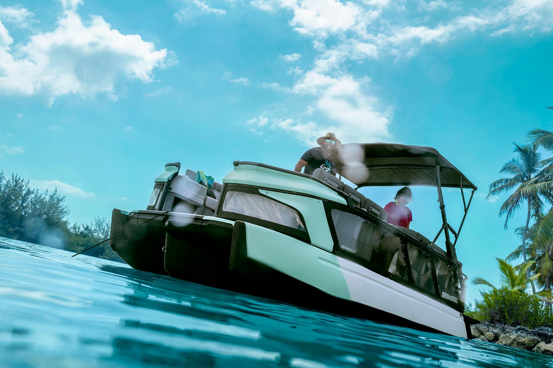 2026 Sea-Doo Switch Cruise 21 on tropical water with palm trees and blue sky.