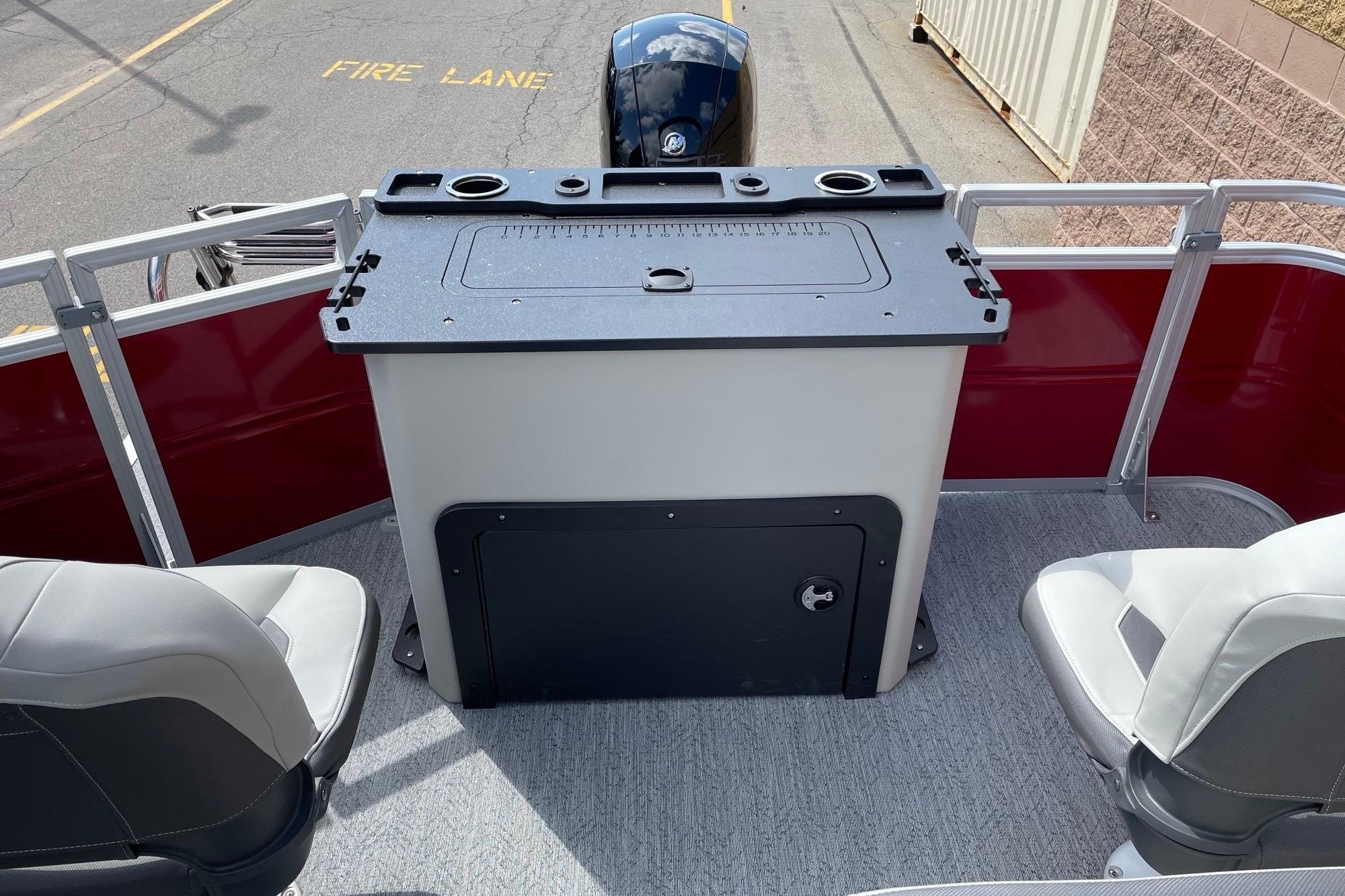 2026 Sun Tracker Fishin' Barge 22 DLX interior with seating and fishing station.