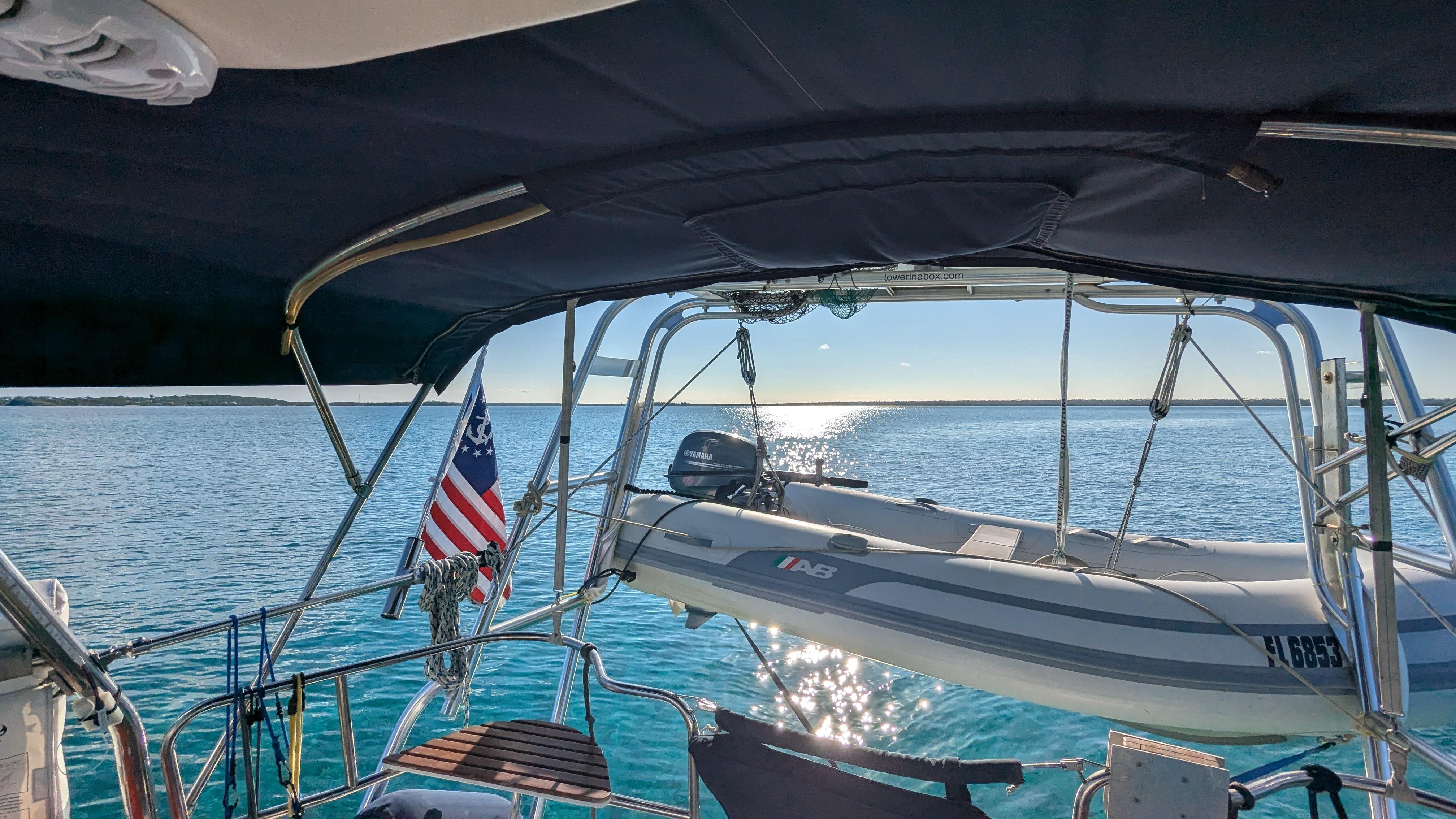 Sailboat Hunter 380 (2001) with dinghy on calm water, American flag visible.