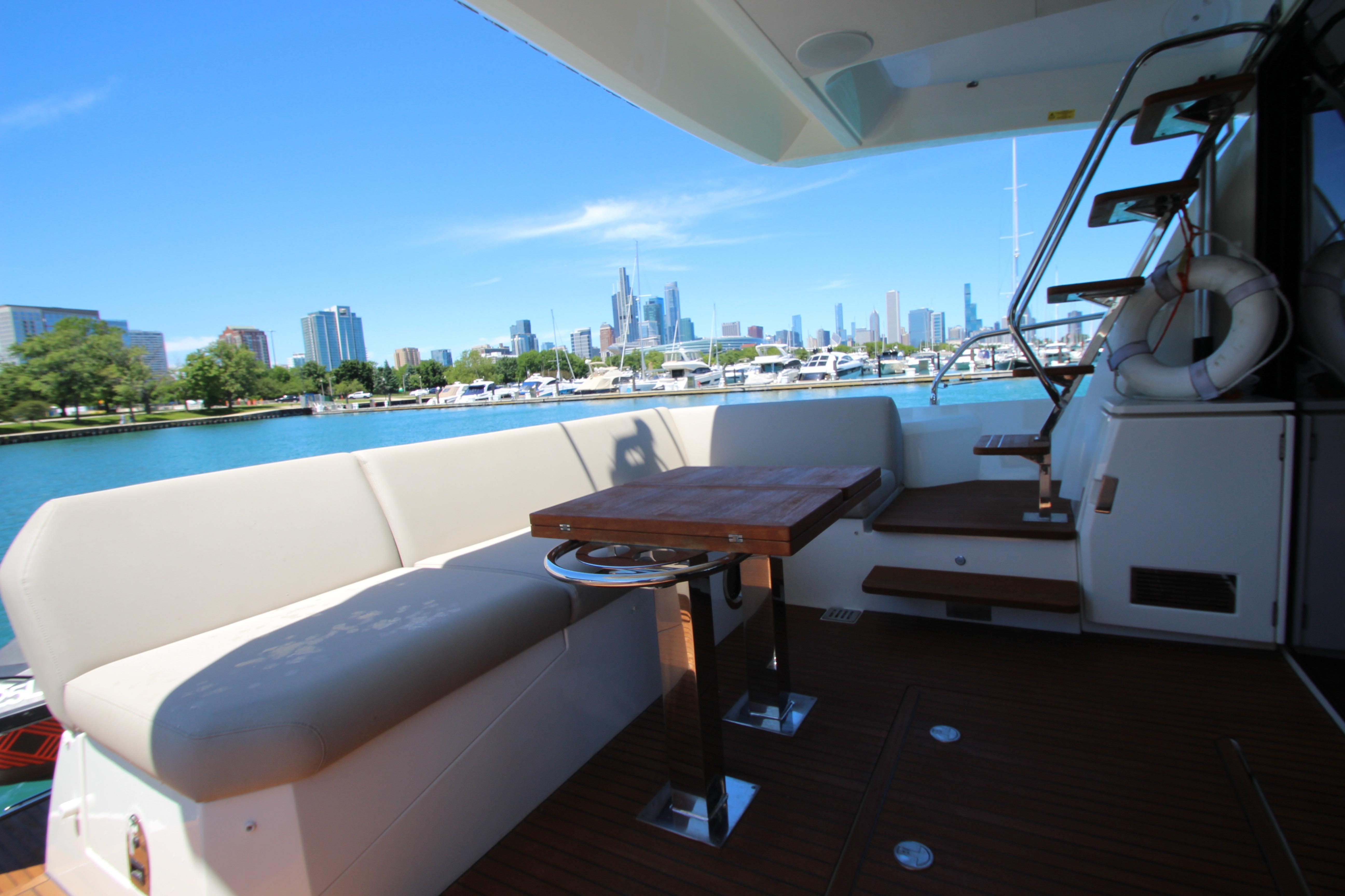 Luxurious 2022 Prestige 520 yacht with city skyline and marina view.