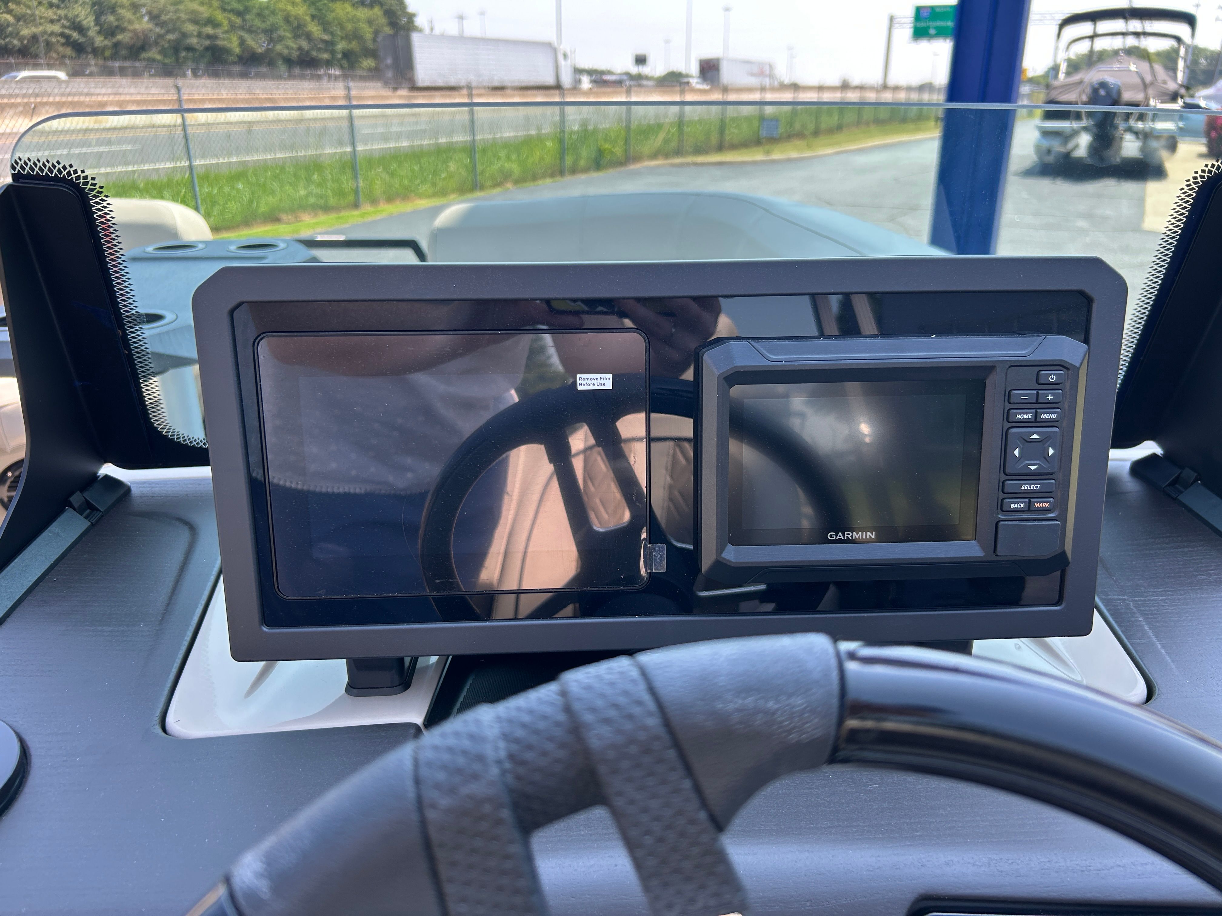 The image shows the dashboard of a Bennington 22 MFB with a Garmin navigation system.