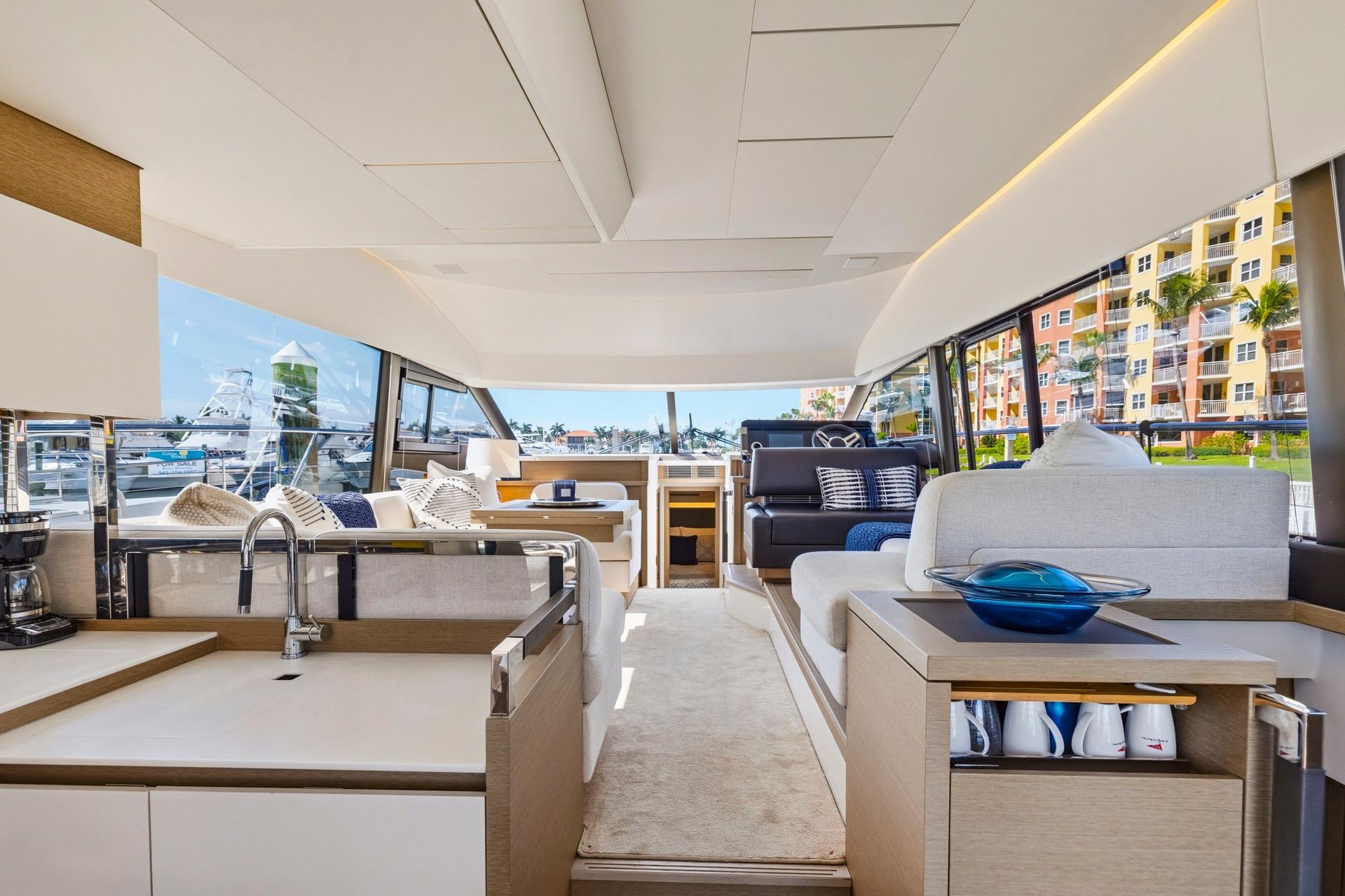 Luxurious interior of 2022 Prestige 520 yacht with modern furnishings and panoramic windows.