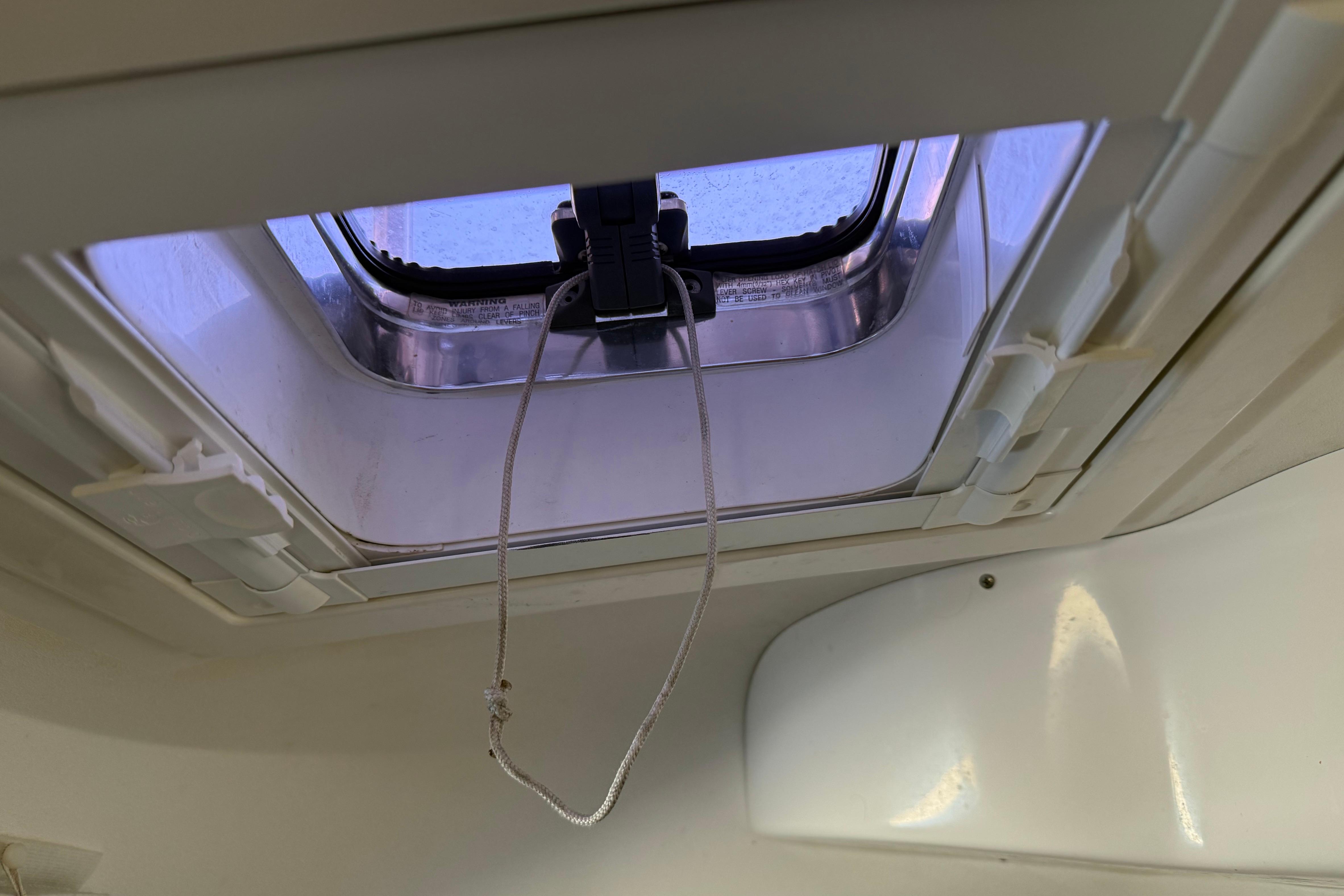 Open hatch on 2004 Sabre 386 sailboat, featuring a secure latch and rope handle.