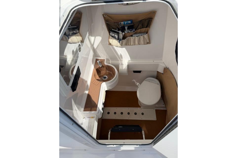 2014 Southport 29 FE boat interior with sink, toilet, and storage compartments.