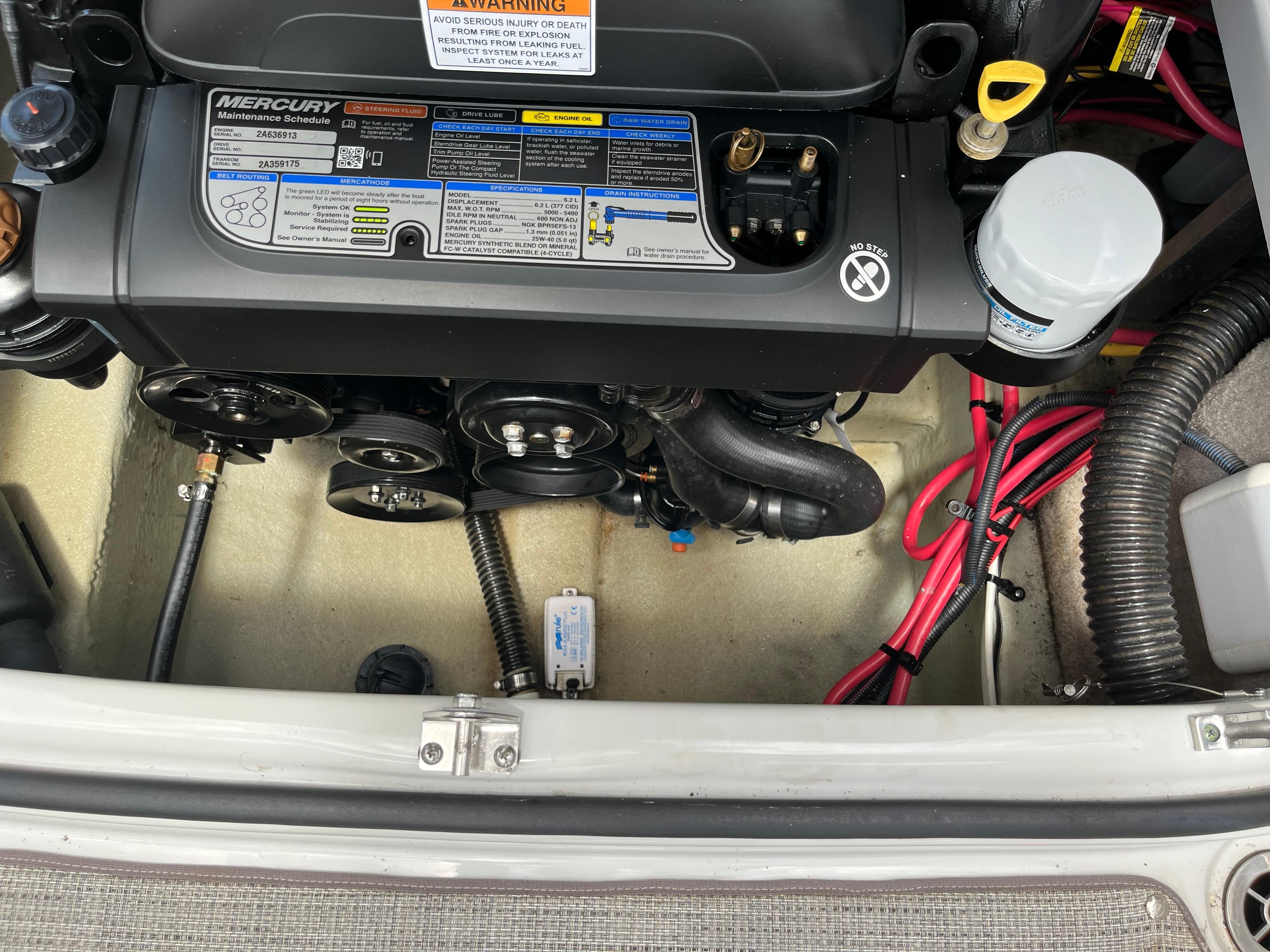 A Mercury engine in a 2019 Crownline E 285 boat, with visible cables and hoses.