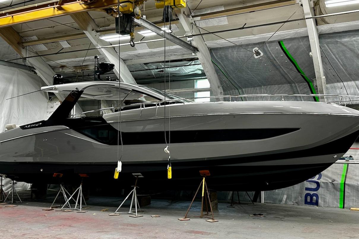 2023 Azimut Verve 47 yacht in a shipyard, elevated on stands.