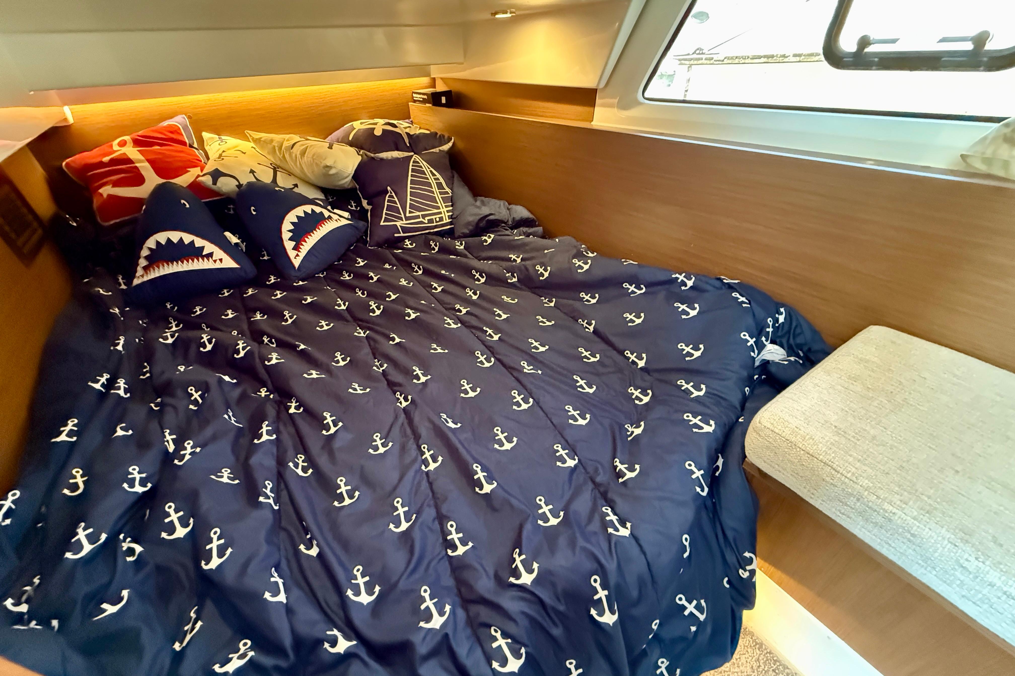 Cozy cabin interior of 2022 Jeanneau NC 1095 Fly with nautical-themed bedding.