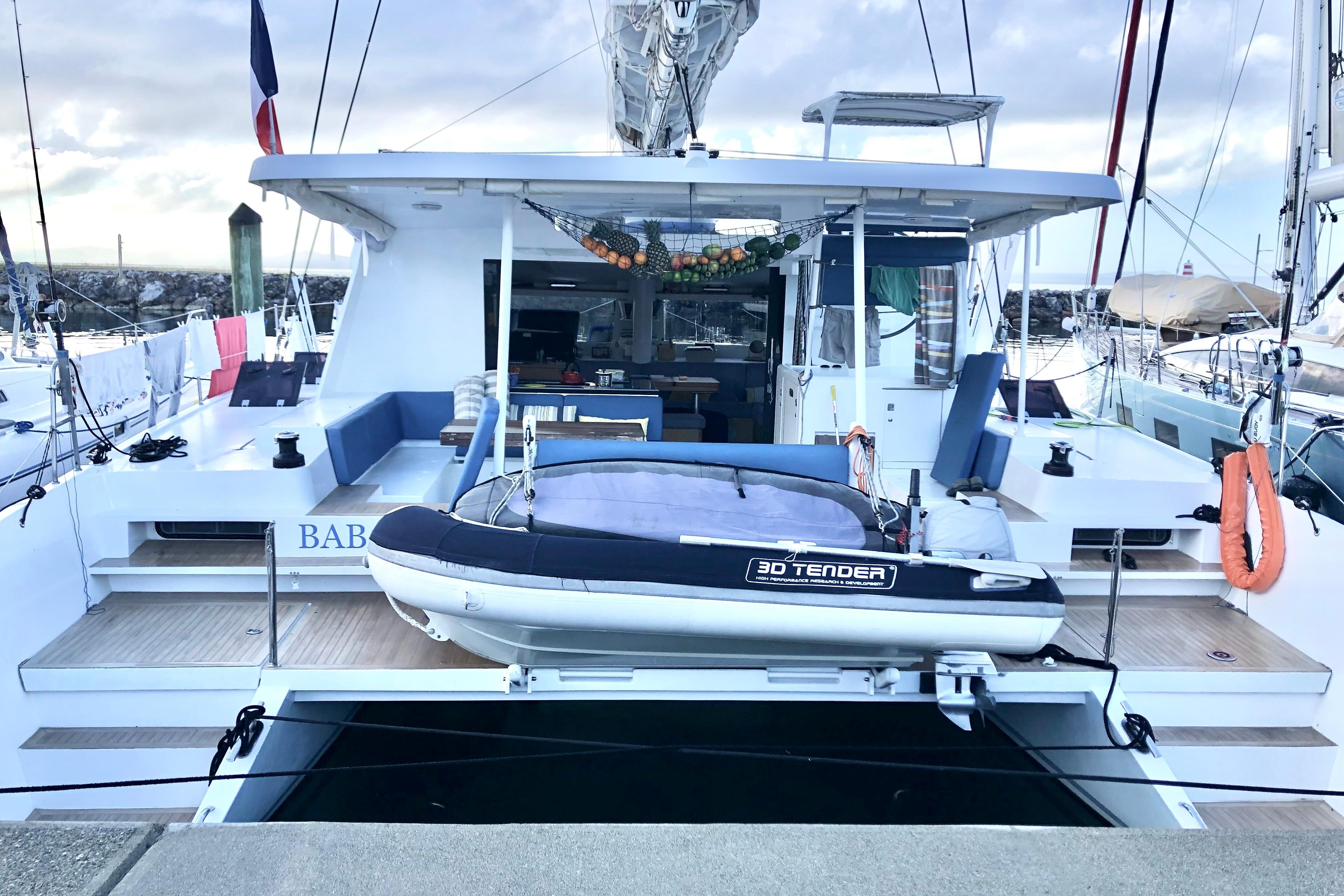 2018 Swiss Cat Yachts 48 with tender docked at marina, featuring spacious deck area.