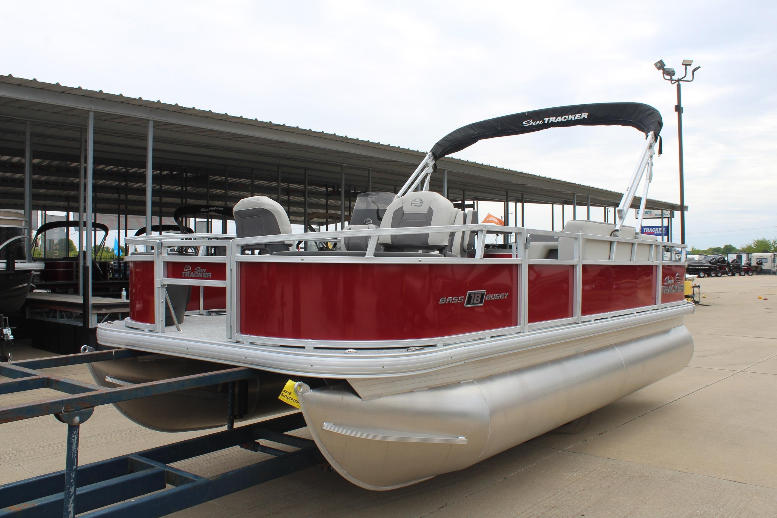 2026 Sun Tracker Bass Buggy 18 DLX pontoon boat with red exterior, parked on trailer.